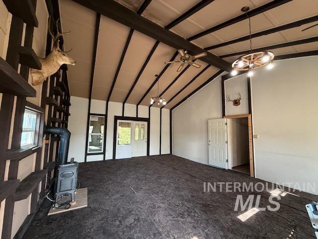 Unfurnished living room with a wood stove and ceiling fan