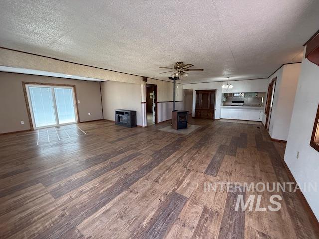 Unfurnished living room featuring dark wood-style floors, a textured ceiling, and a ceiling fan