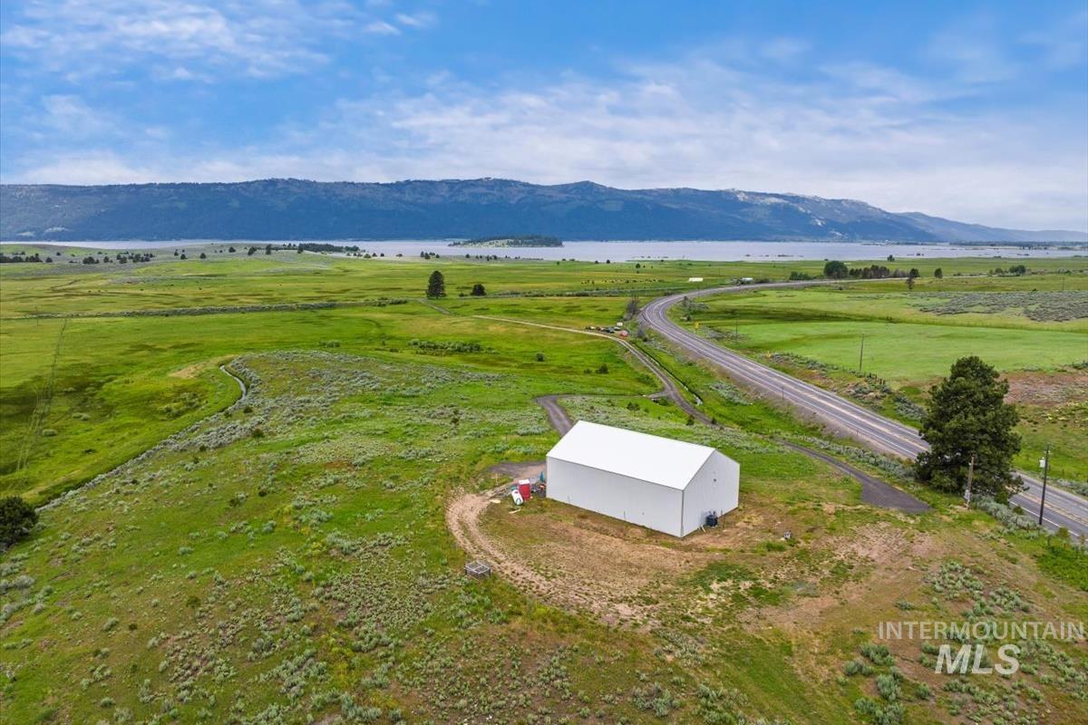 Aerial view of sparsely populated area featuring a pastoral area and a water and mountain view