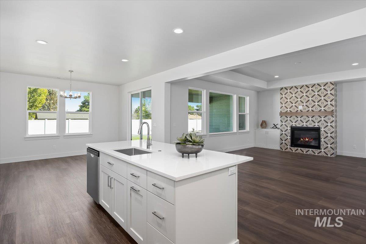 Kitchen featuring open floor plan, decorative light fixtures, white cabinets, dark wood-type flooring, and recessed lighting