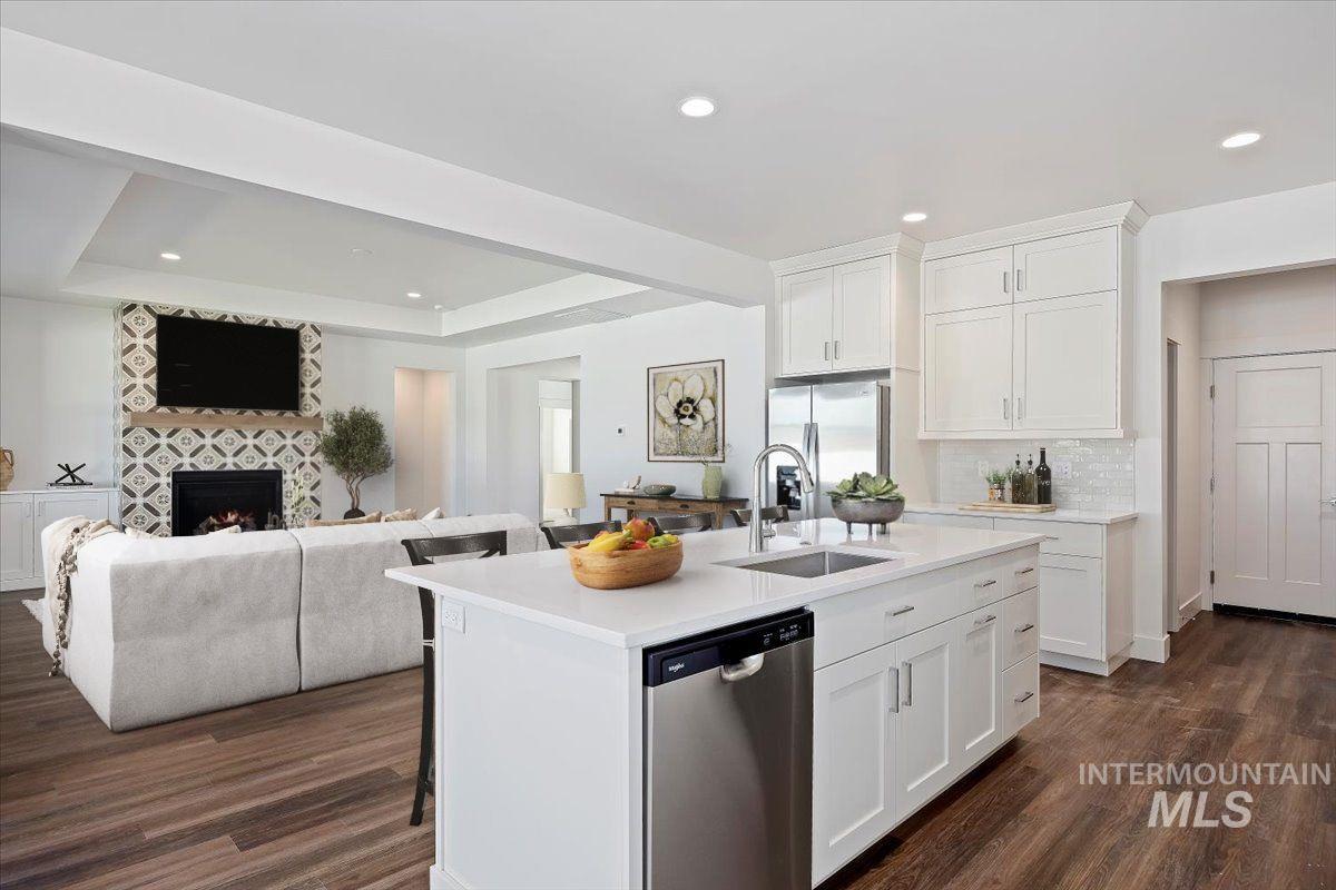 Kitchen with white cabinets, stainless steel appliances, dark wood finished floors, open floor plan, and recessed lighting