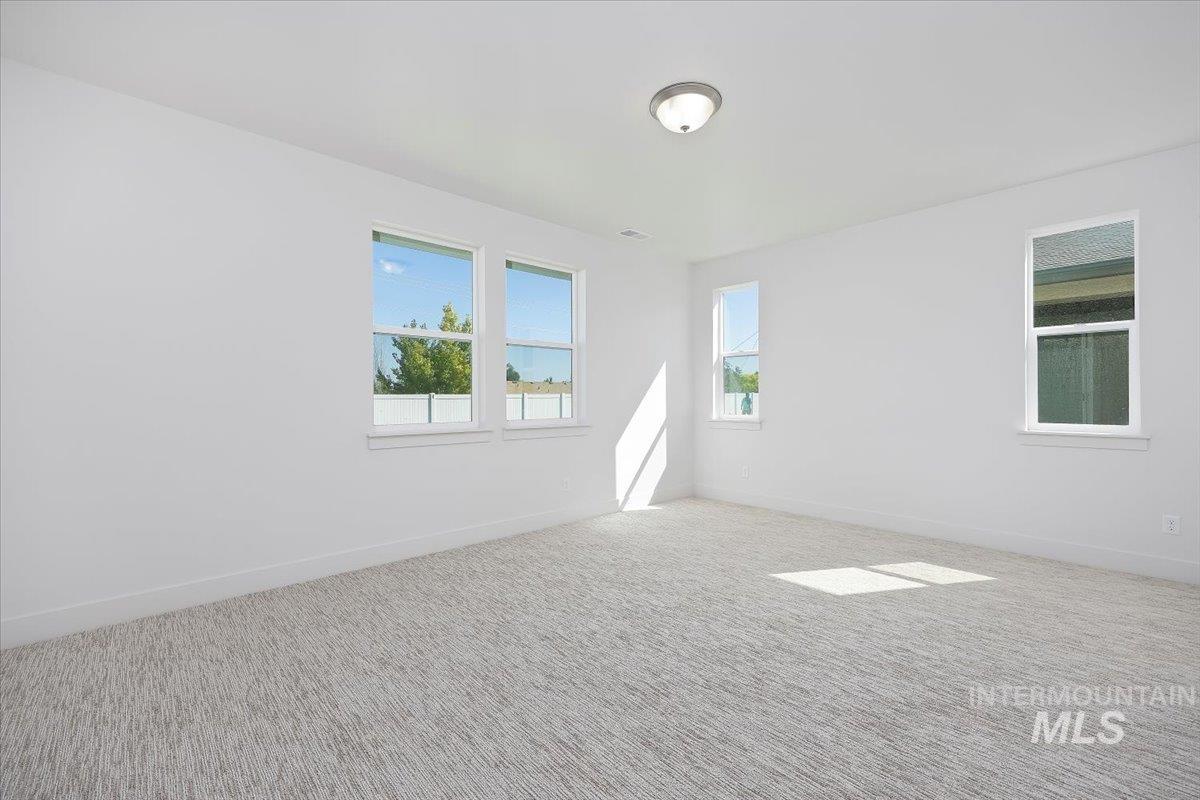 Carpeted empty room featuring baseboards