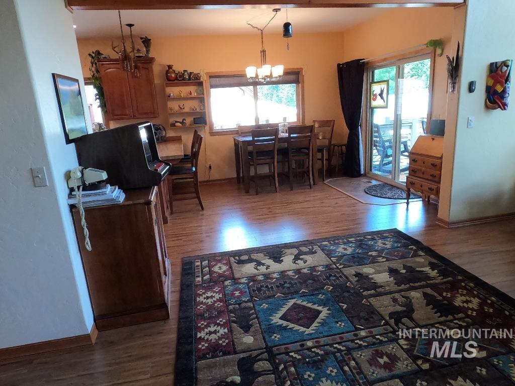 Dining area with a chandelier, wood finished floors, and healthy amount of natural light