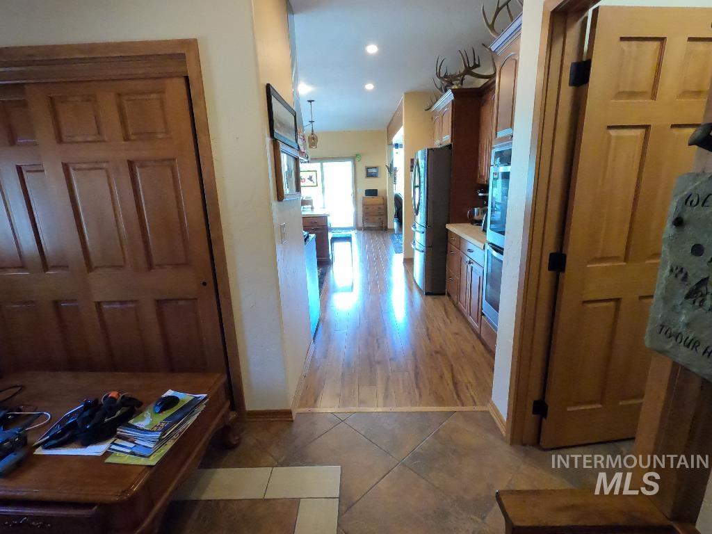 Hallway with light tile patterned floors and recessed lighting