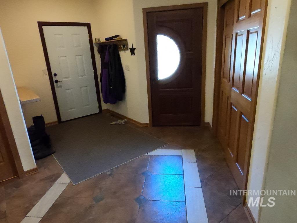 Entrance foyer with baseboards and dark tile patterned floors