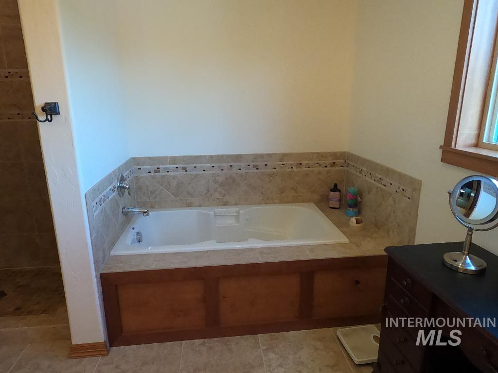 Bathroom with a bath and tile patterned flooring