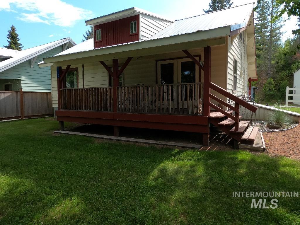Rear view of property featuring a metal roof and a porch