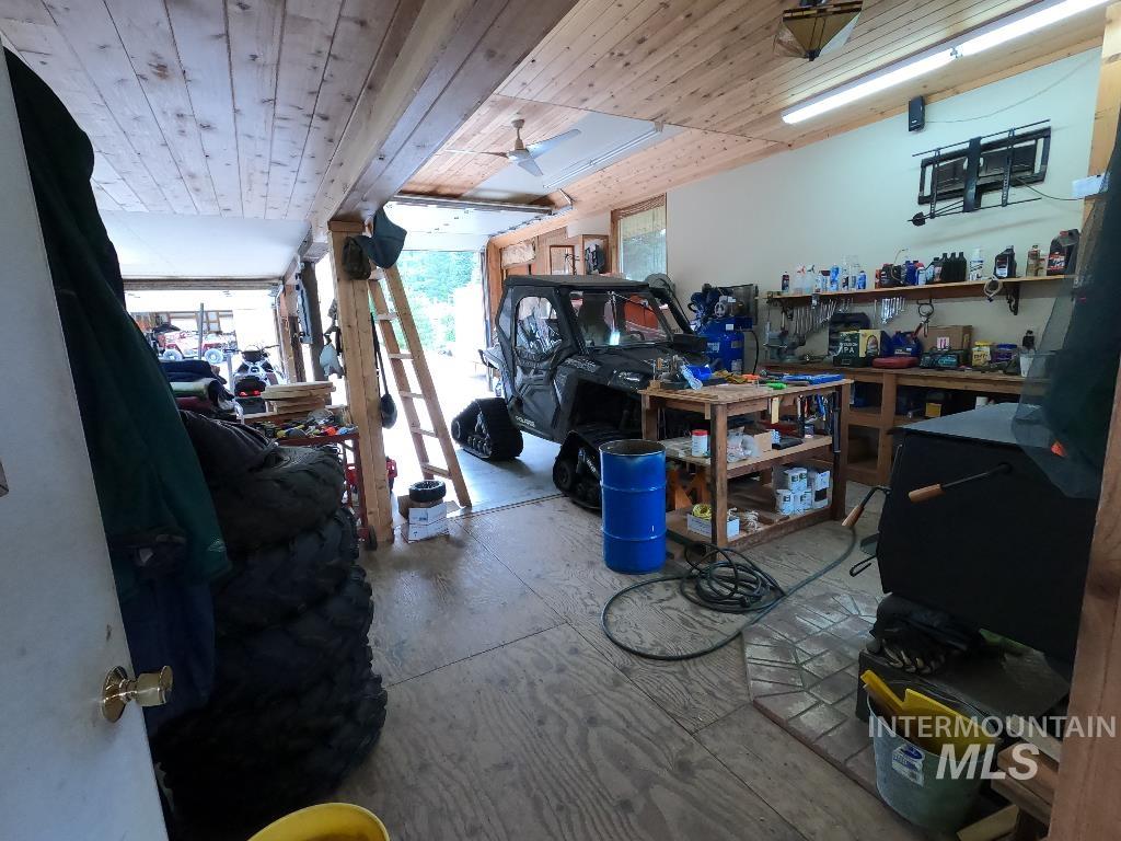 Misc room featuring a workshop area, wooden ceiling, and a ceiling fan