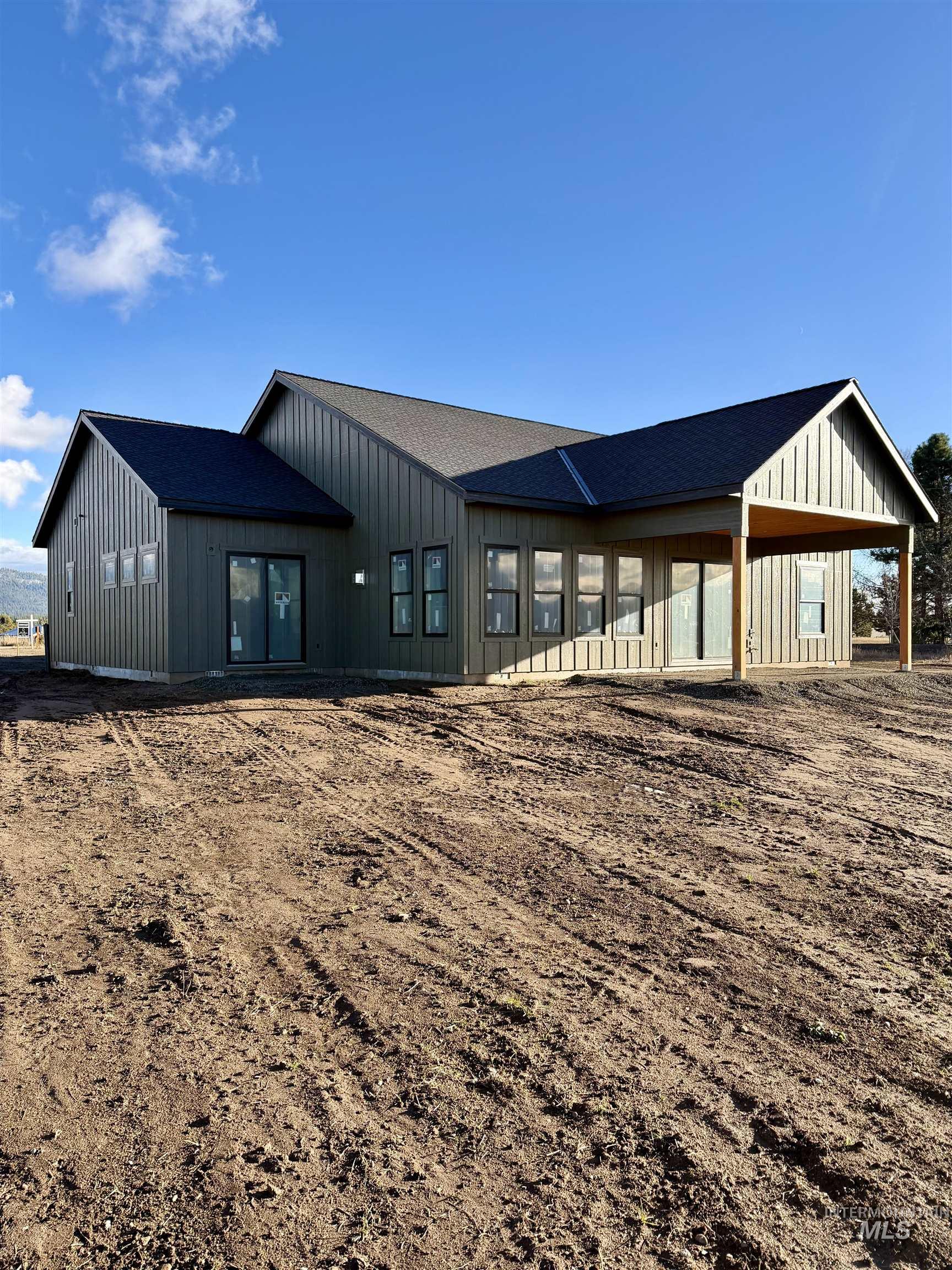 Back of property featuring board and batten siding and roof with shingles