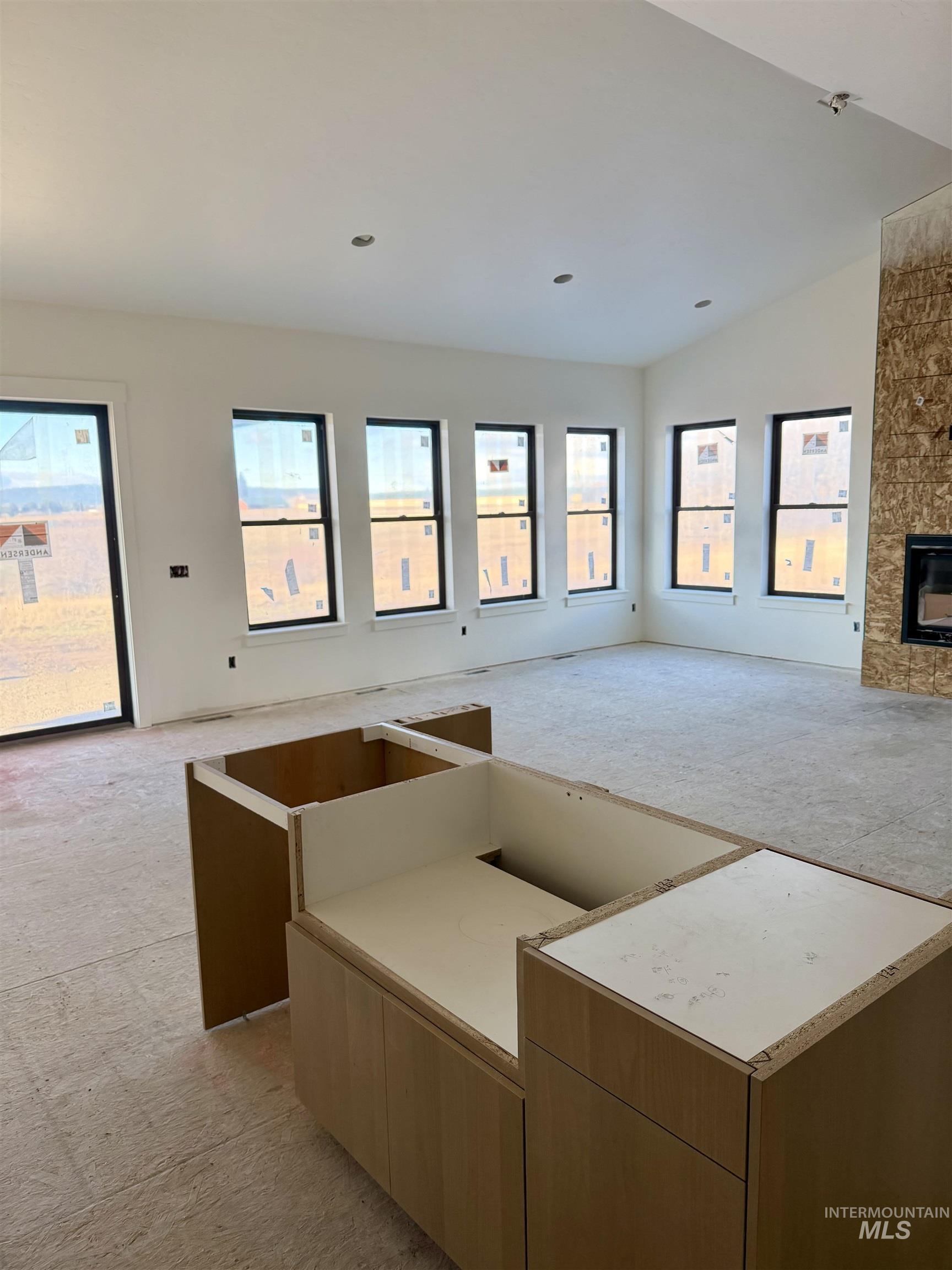 Kitchen featuring open floor plan, light colored carpet, plenty of natural light, and vaulted ceiling