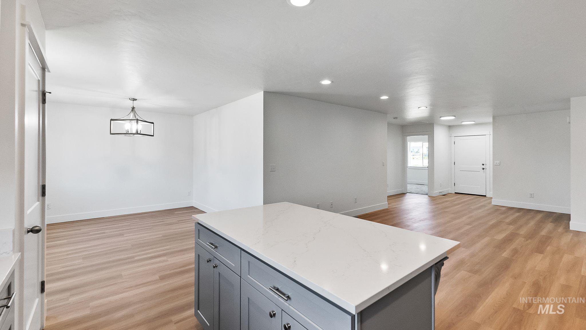Kitchen featuring gray cabinets, open floor plan, a center island, recessed lighting, and hanging light fixtures