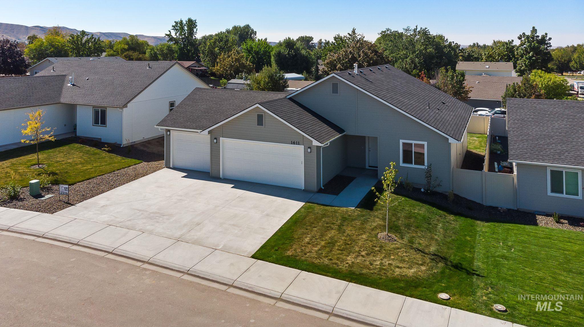View of front of house featuring a garage, driveway, a residential view, and roof with shingles
