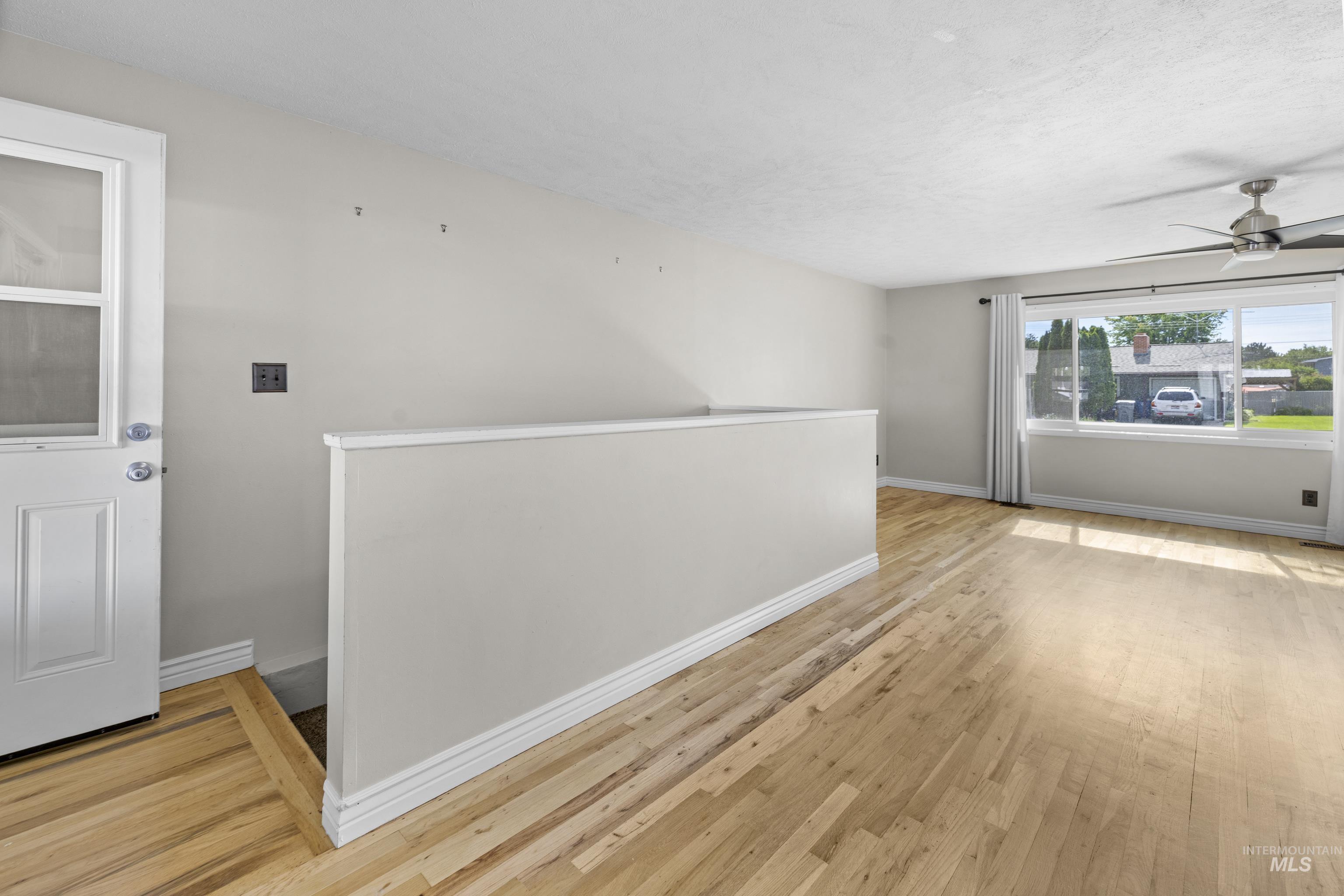 Unfurnished room featuring light wood-style flooring and ceiling fan