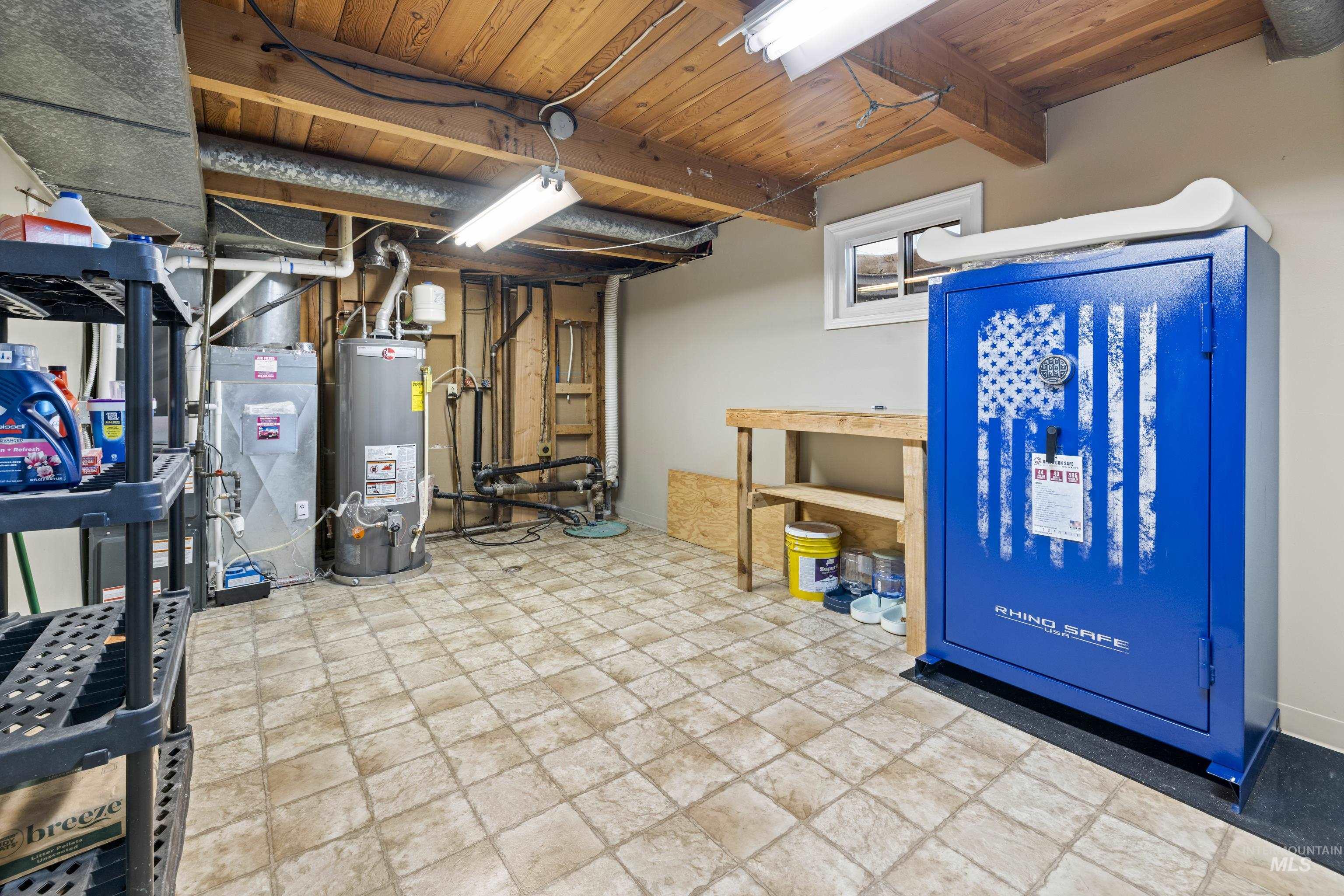 Basement featuring gas water heater, stone finish floors, and wood ceiling