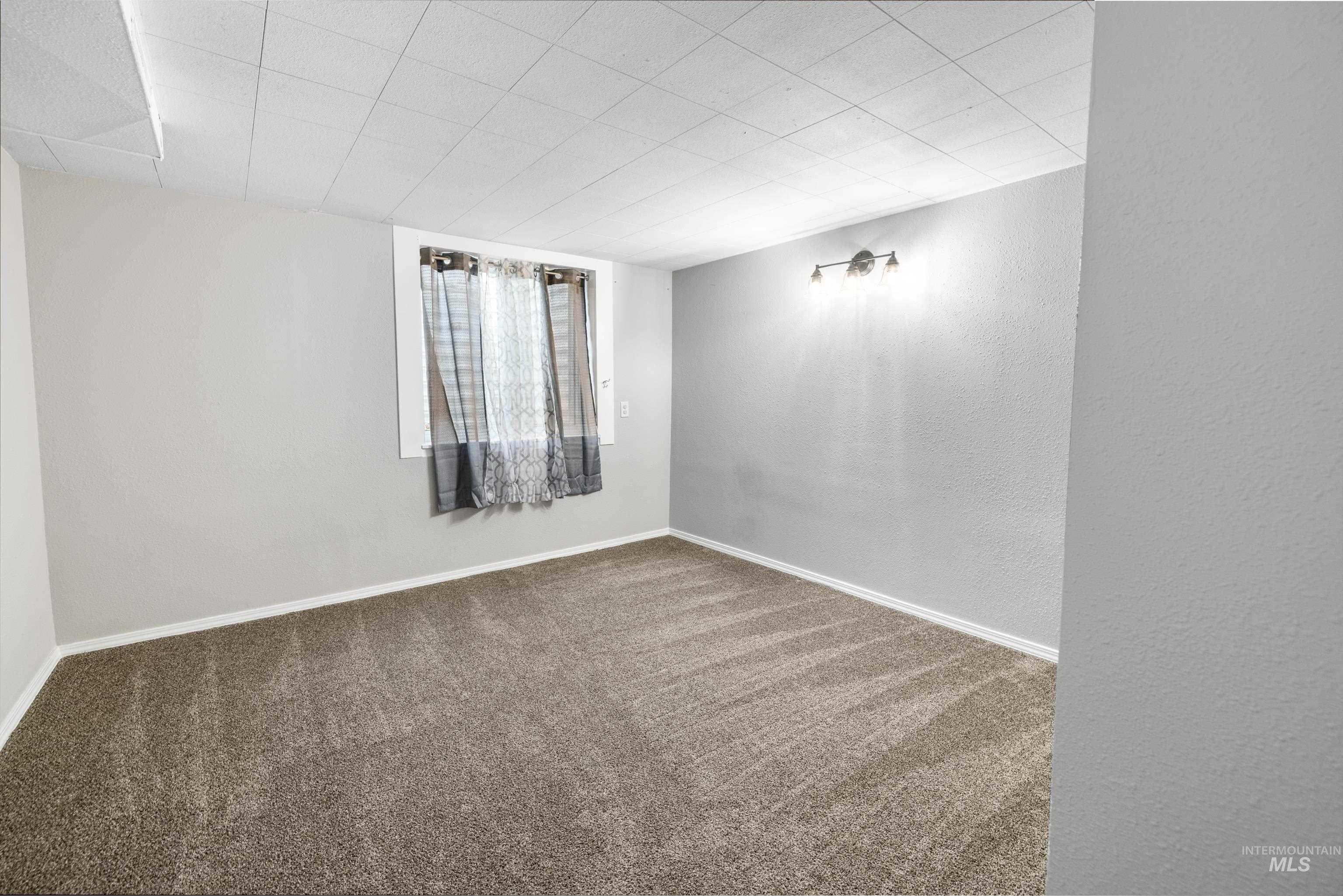 Carpeted empty room featuring baseboards