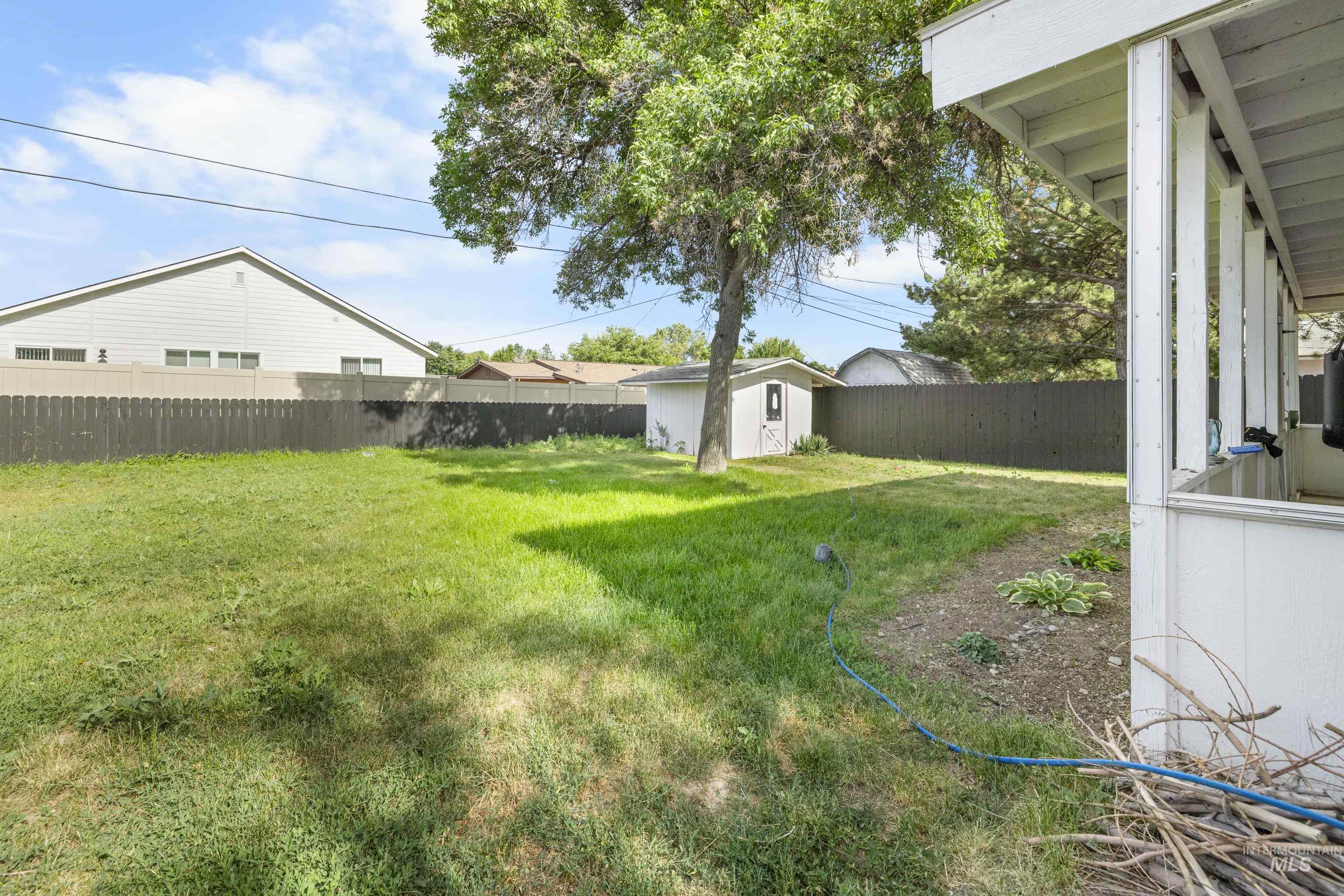 Fenced backyard with a storage shed