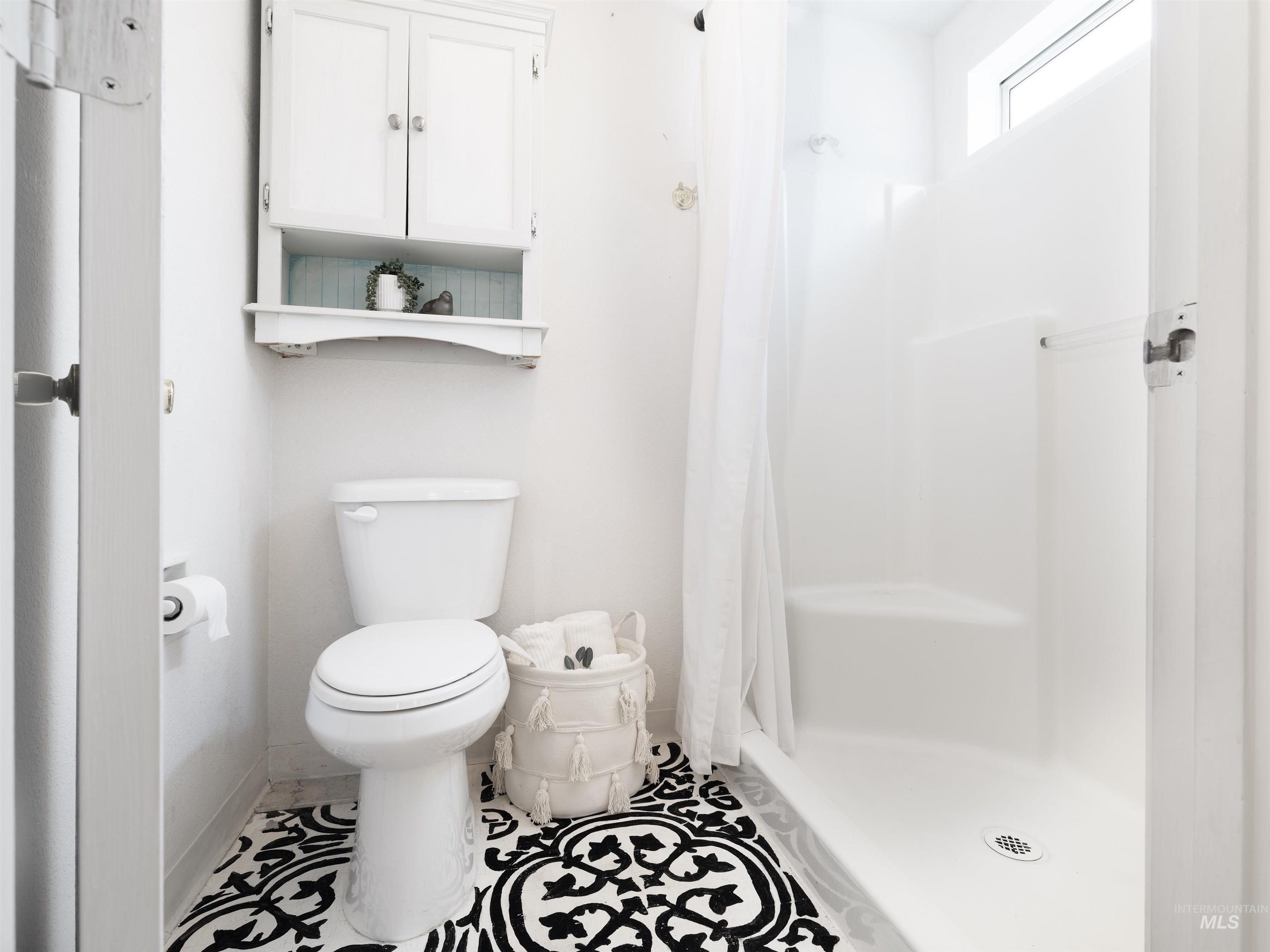 Full bathroom featuring toilet and a shower with curtain