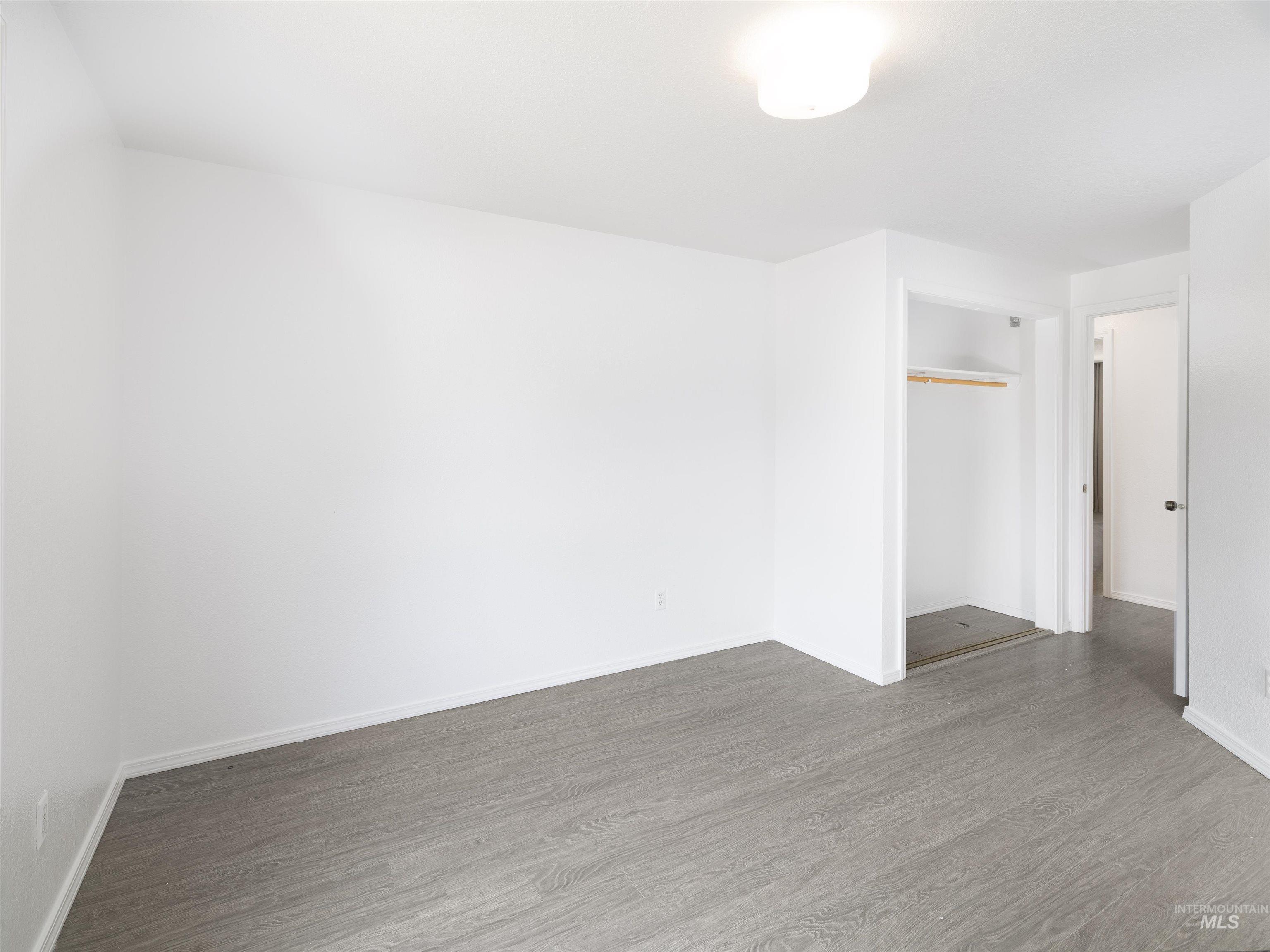 Spare room featuring dark wood-style flooring