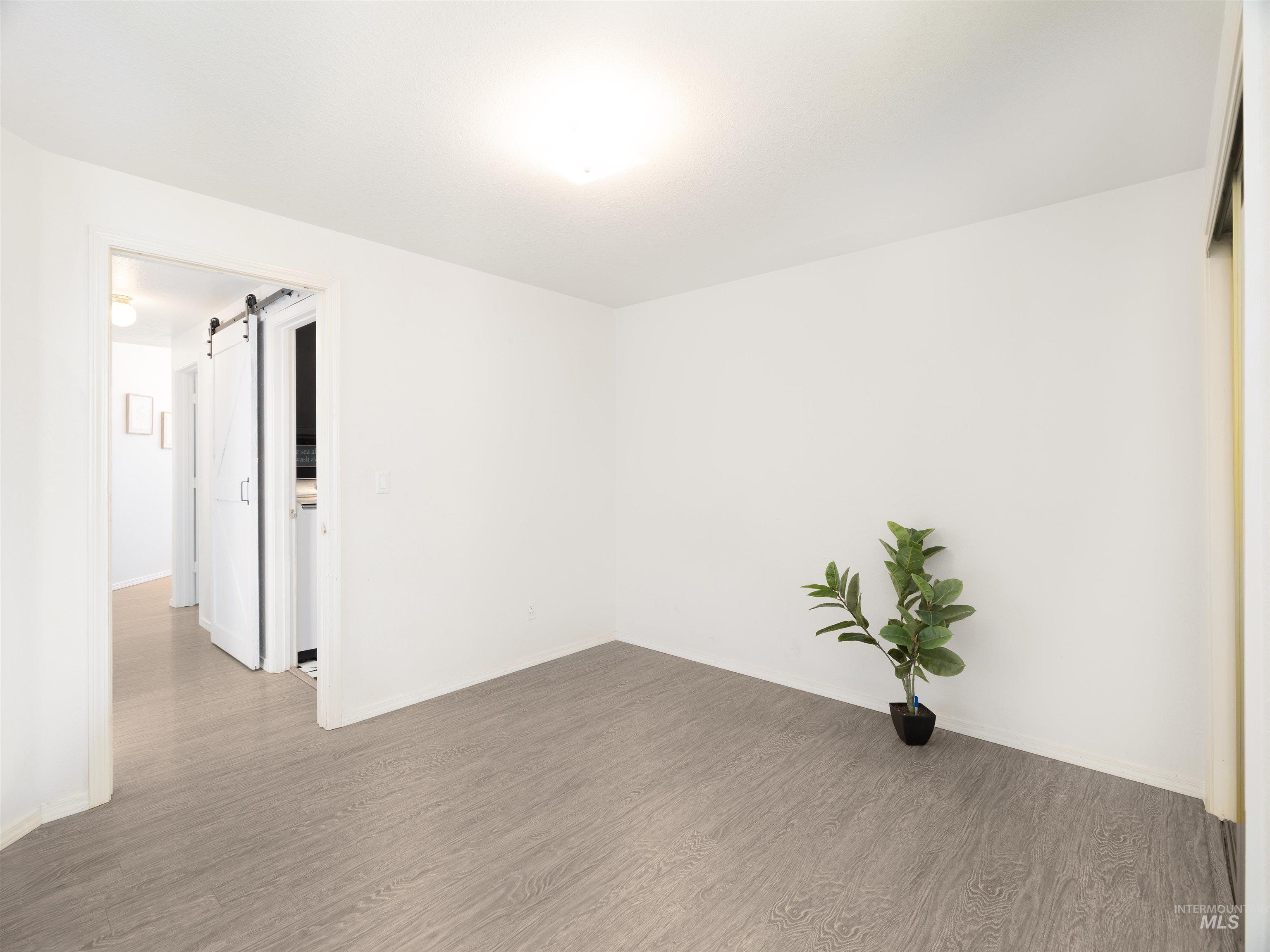 Spare room featuring a barn door and wood finished floors