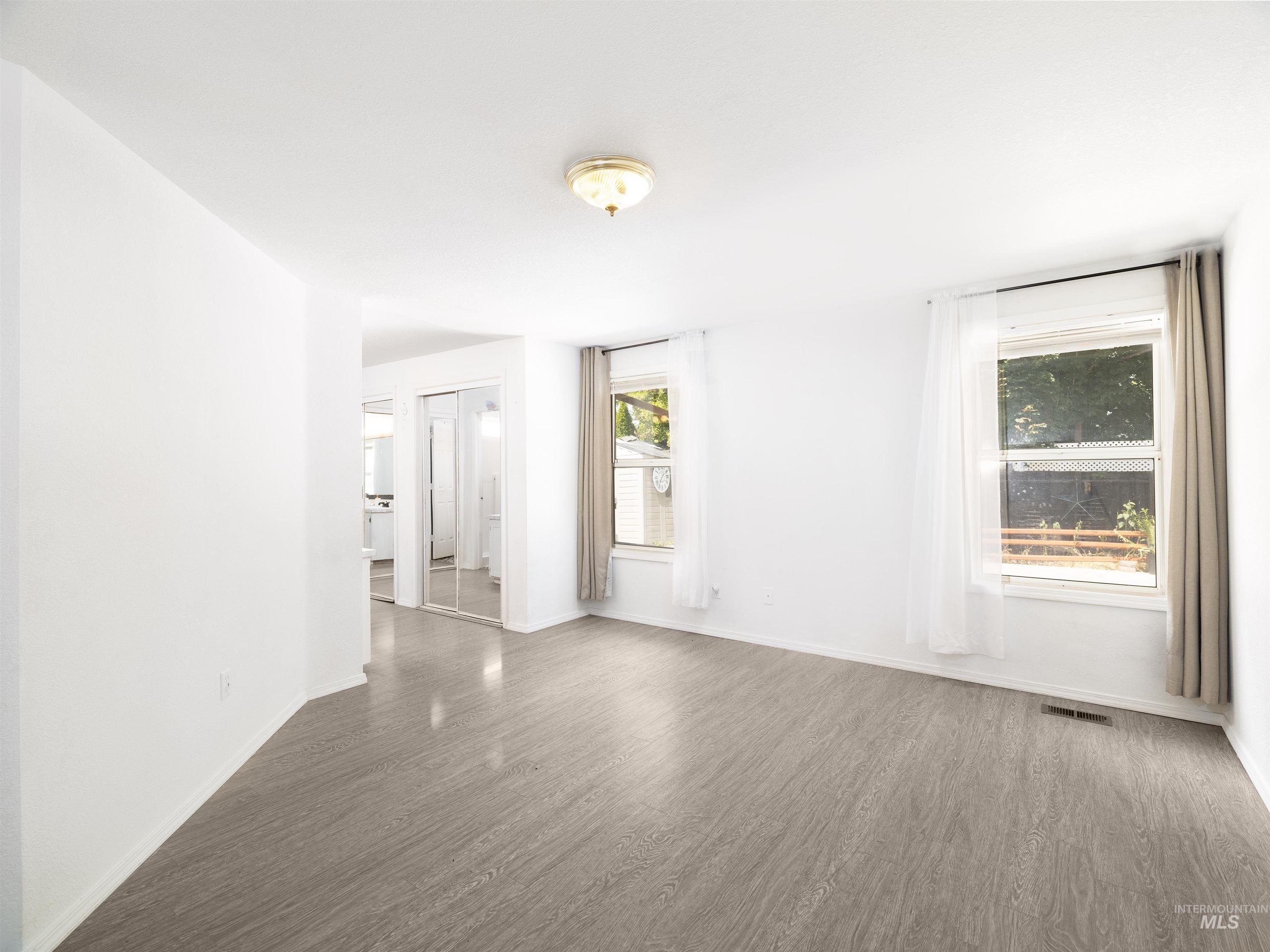 Unfurnished room featuring wood finished floors and baseboards
