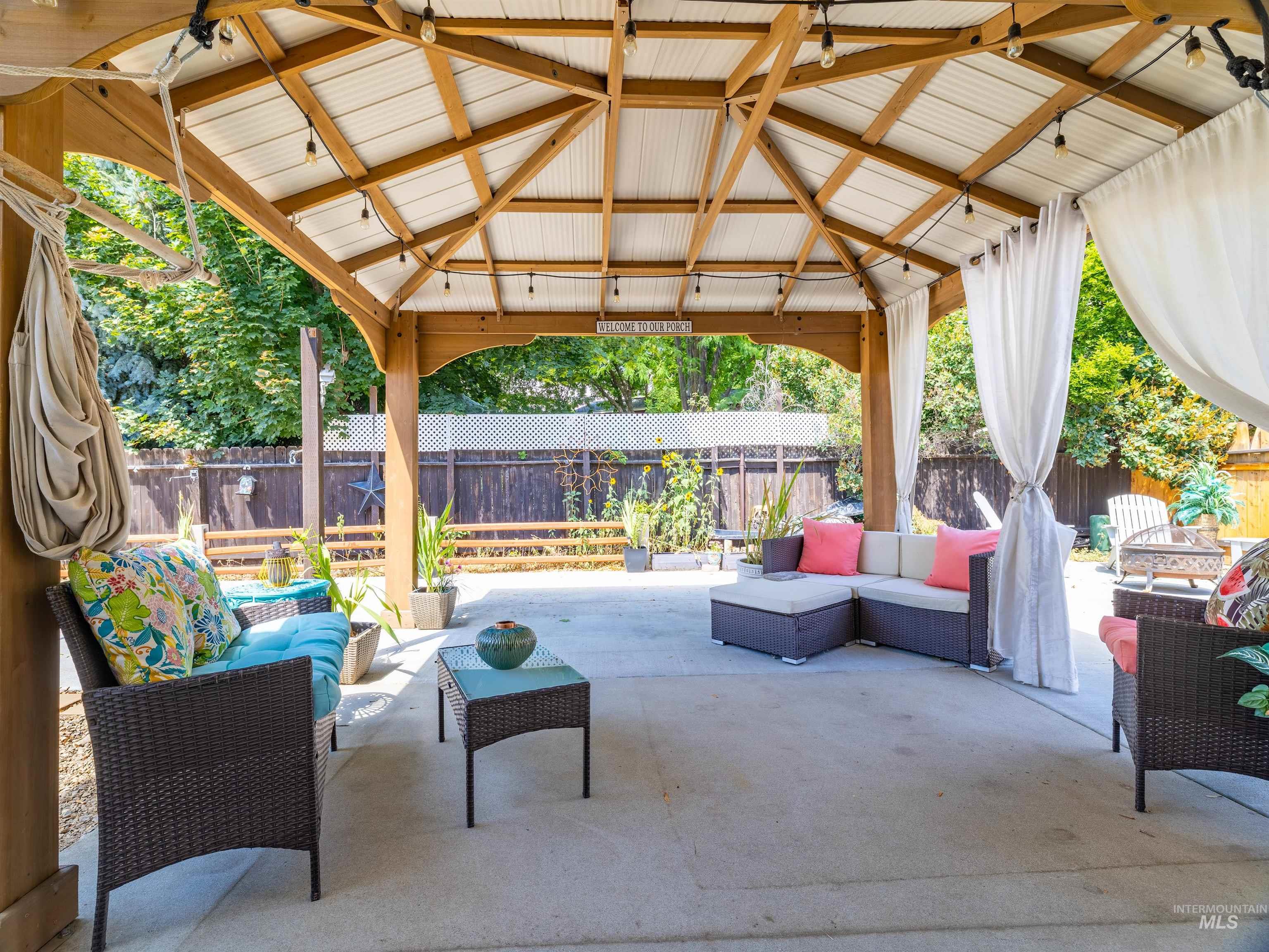 Fenced backyard with an outdoor hangout area, a gazebo, and a patio area