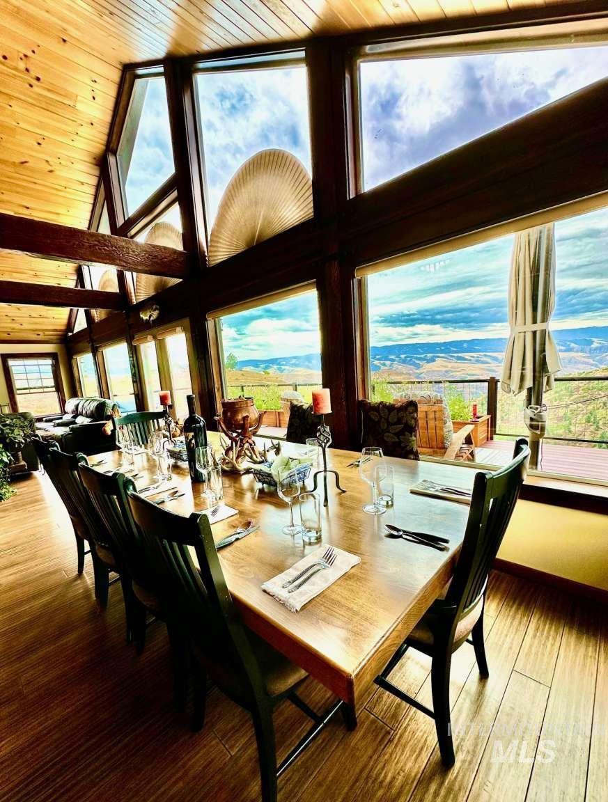 Dining area featuring a wood ceiling with exposed beams, wood finished floors, and high vaulted ceiling