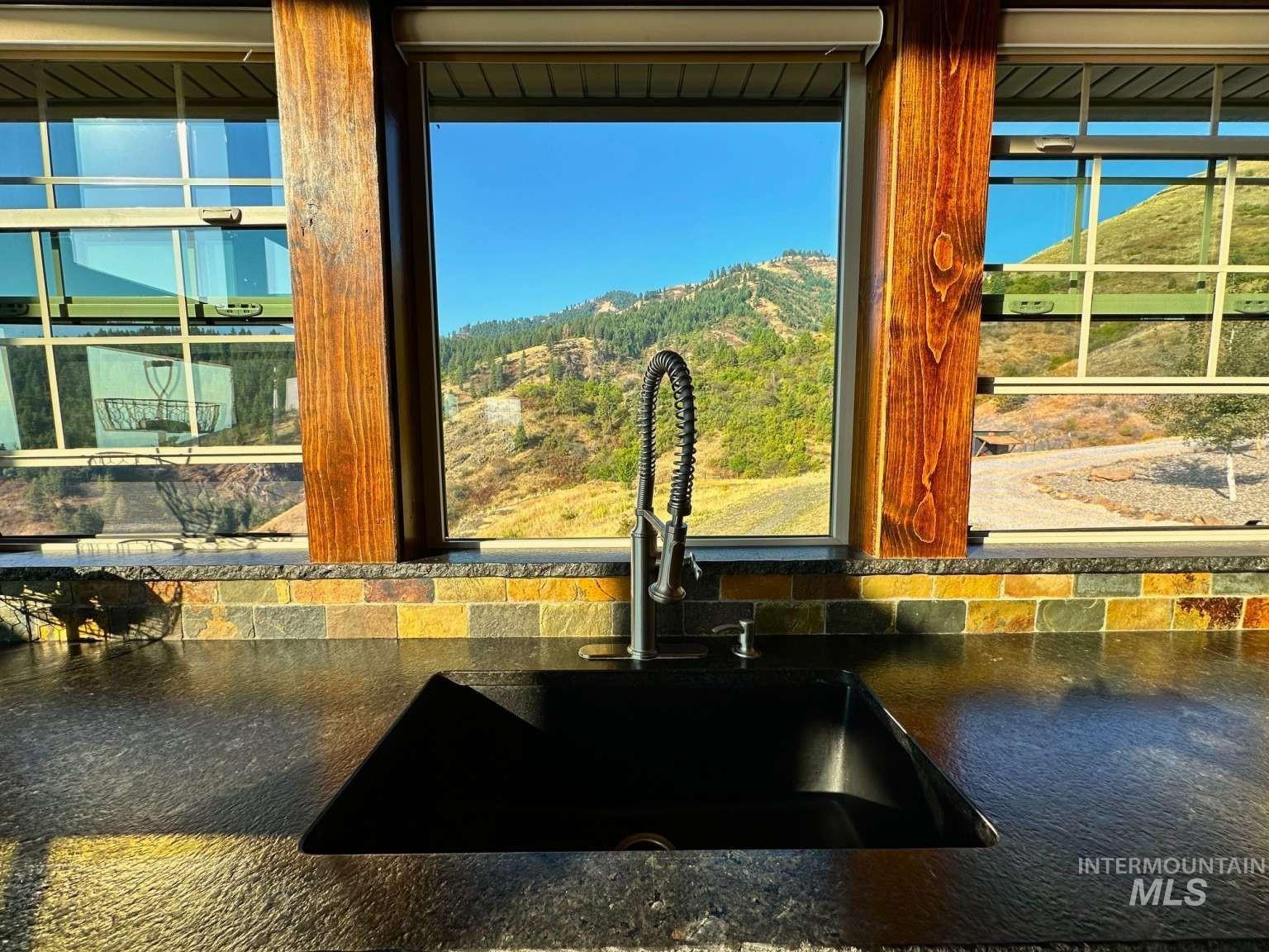 Kitchen view of mountains, backsplash, and dark stone countertops