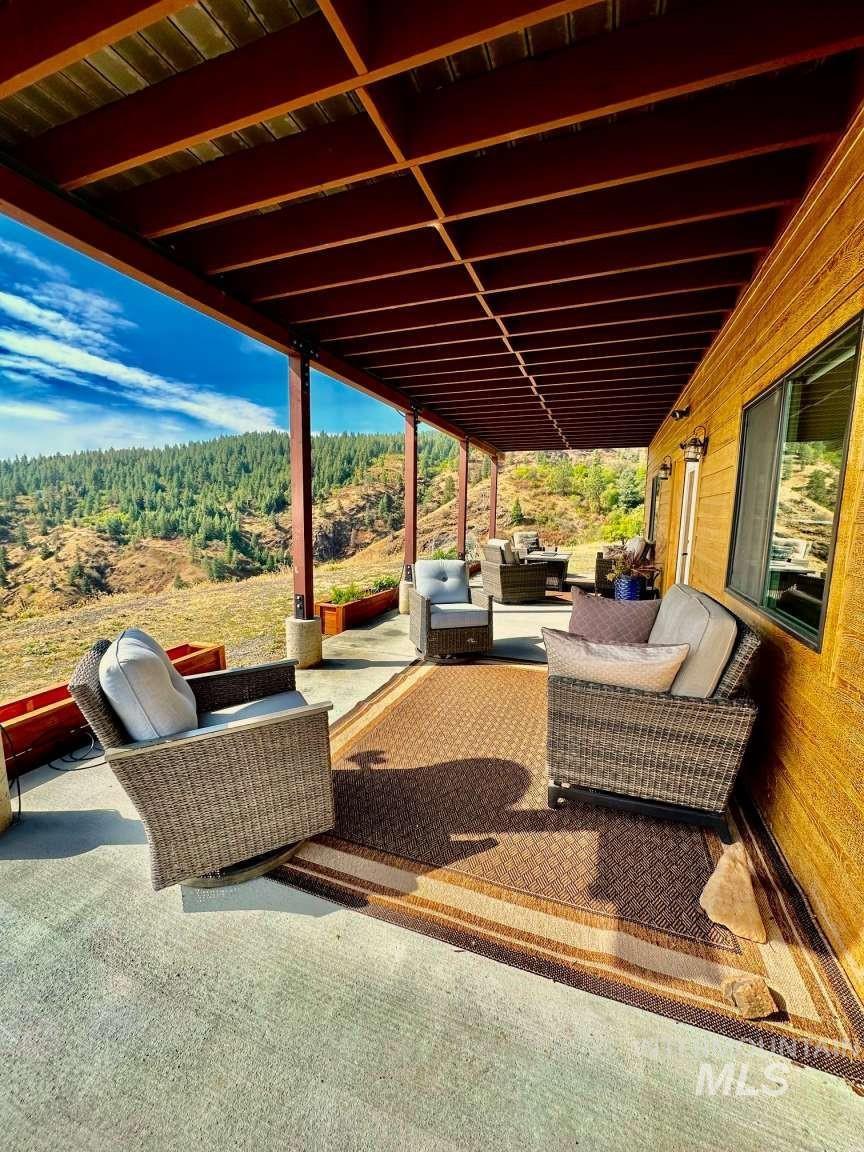 View of patio / terrace with an outdoor hangout area and a view of trees