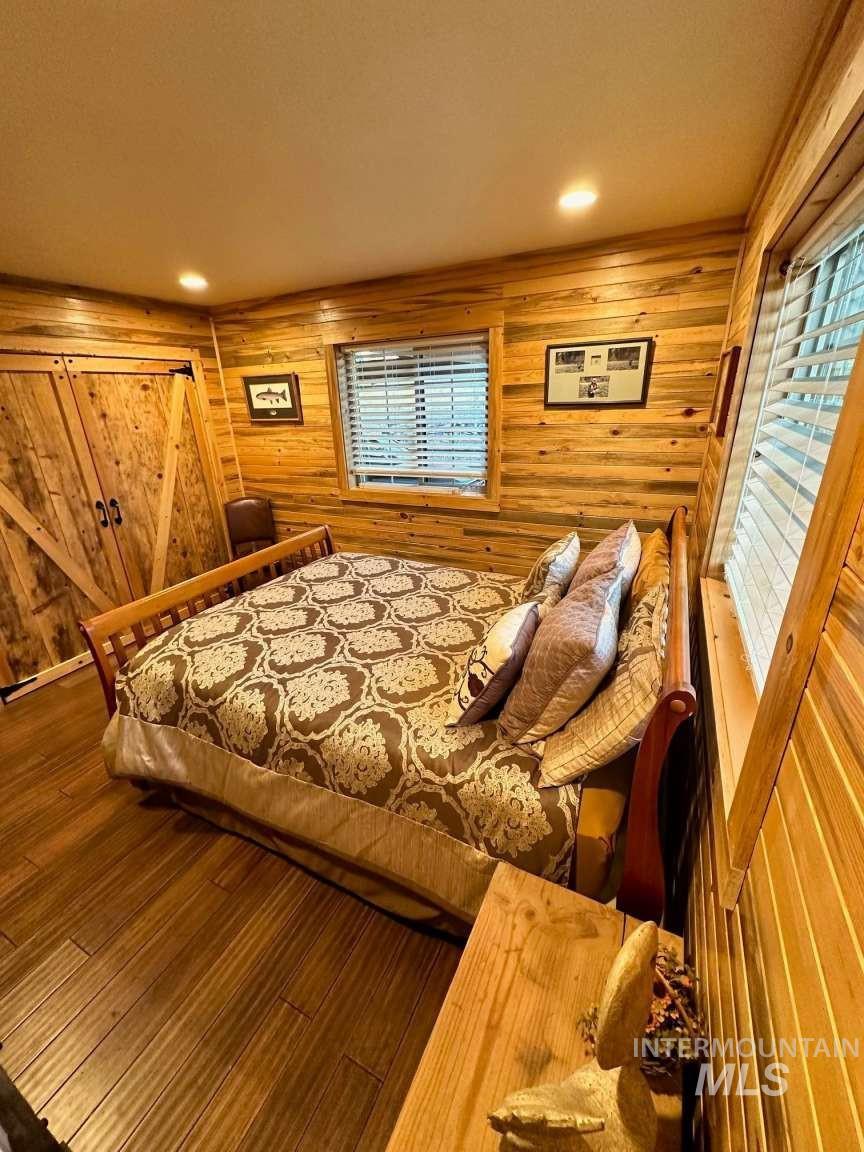 Bedroom featuring wood finished floors and wooden walls
