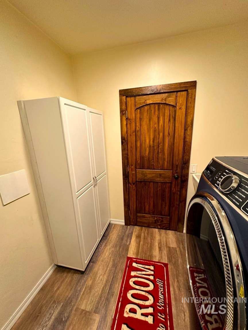 Laundry room featuring washer / clothes dryer and dark wood-style flooring