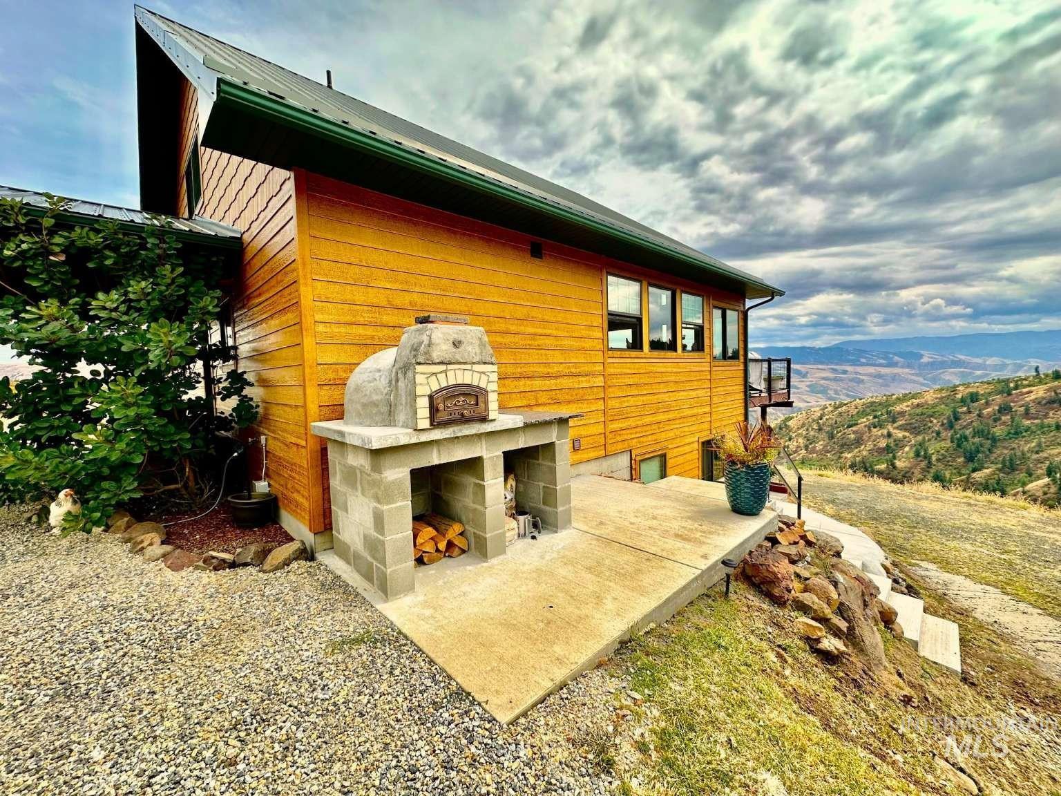 View of home's exterior featuring a patio area and an outdoor fireplace