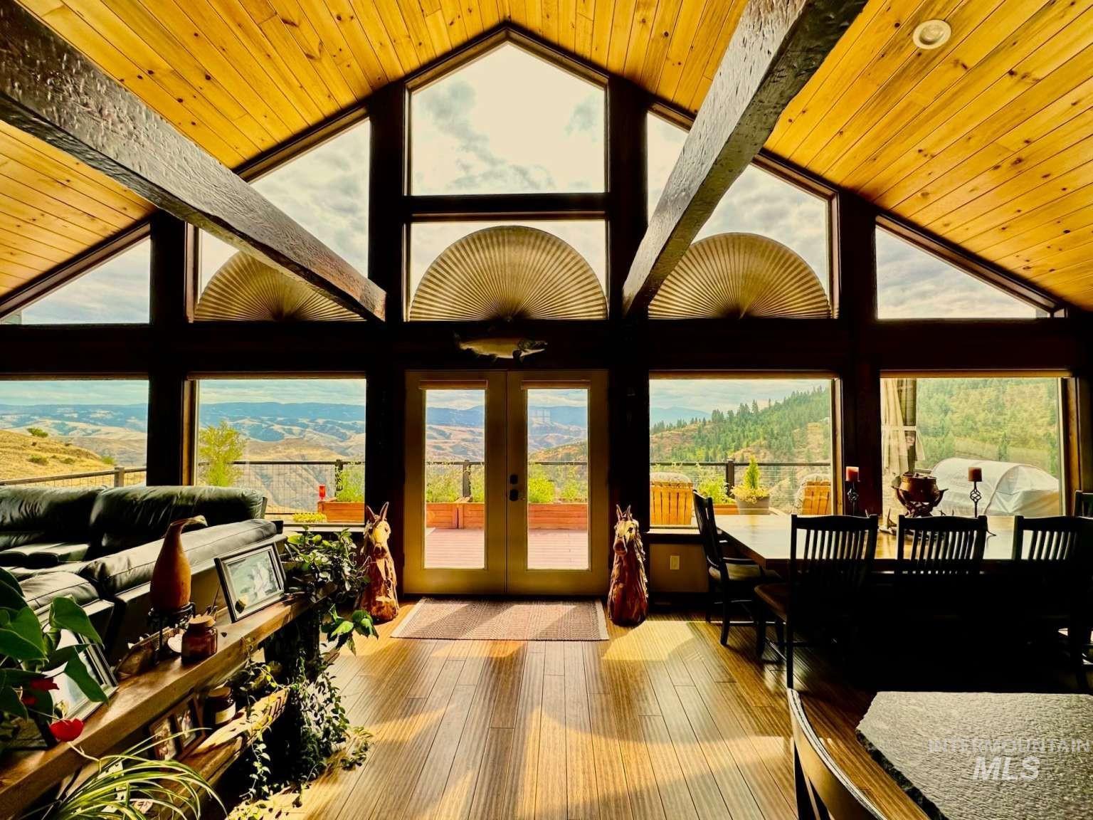 Sunroom featuring lofted ceiling, french doors, and a mountain view