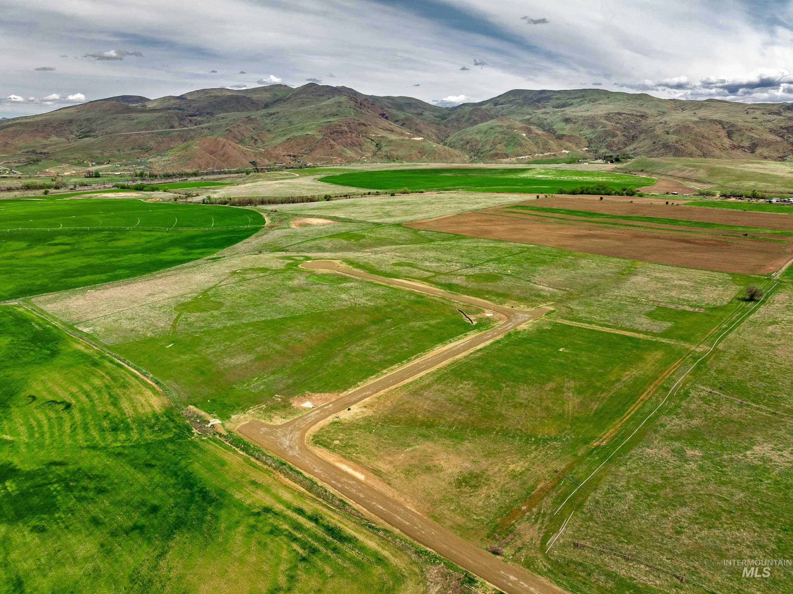 Aerial view of property's location featuring a mountainous background and rural landscape
