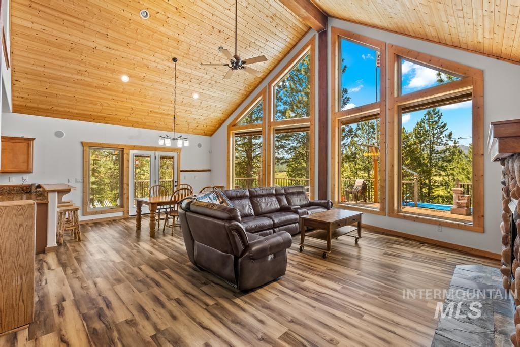 Living area with high vaulted ceiling, a wood ceiling with exposed beams, light wood-style flooring, a ceiling fan, and recessed lighting
