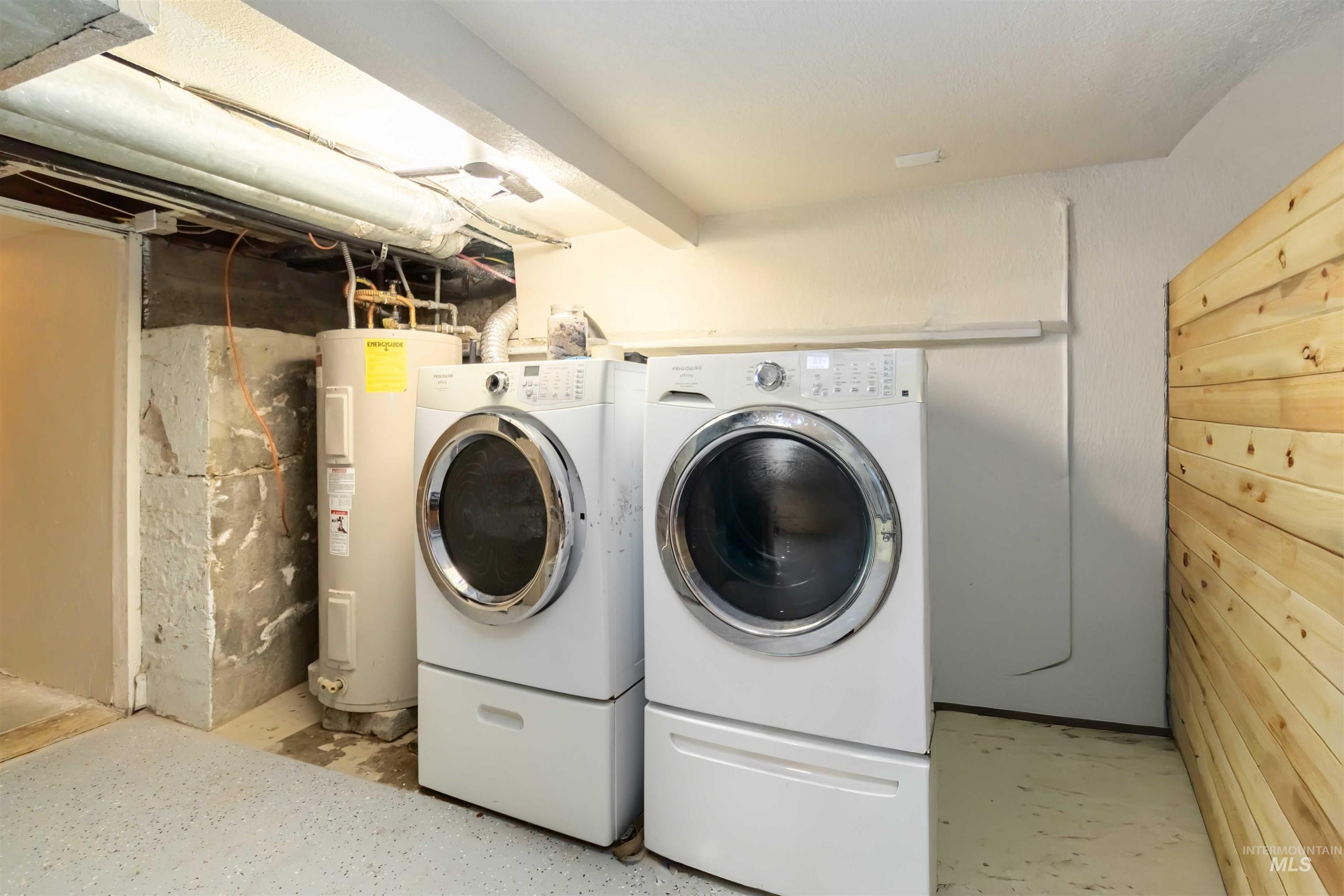 Laundry area with electric water heater and washing machine and clothes dryer