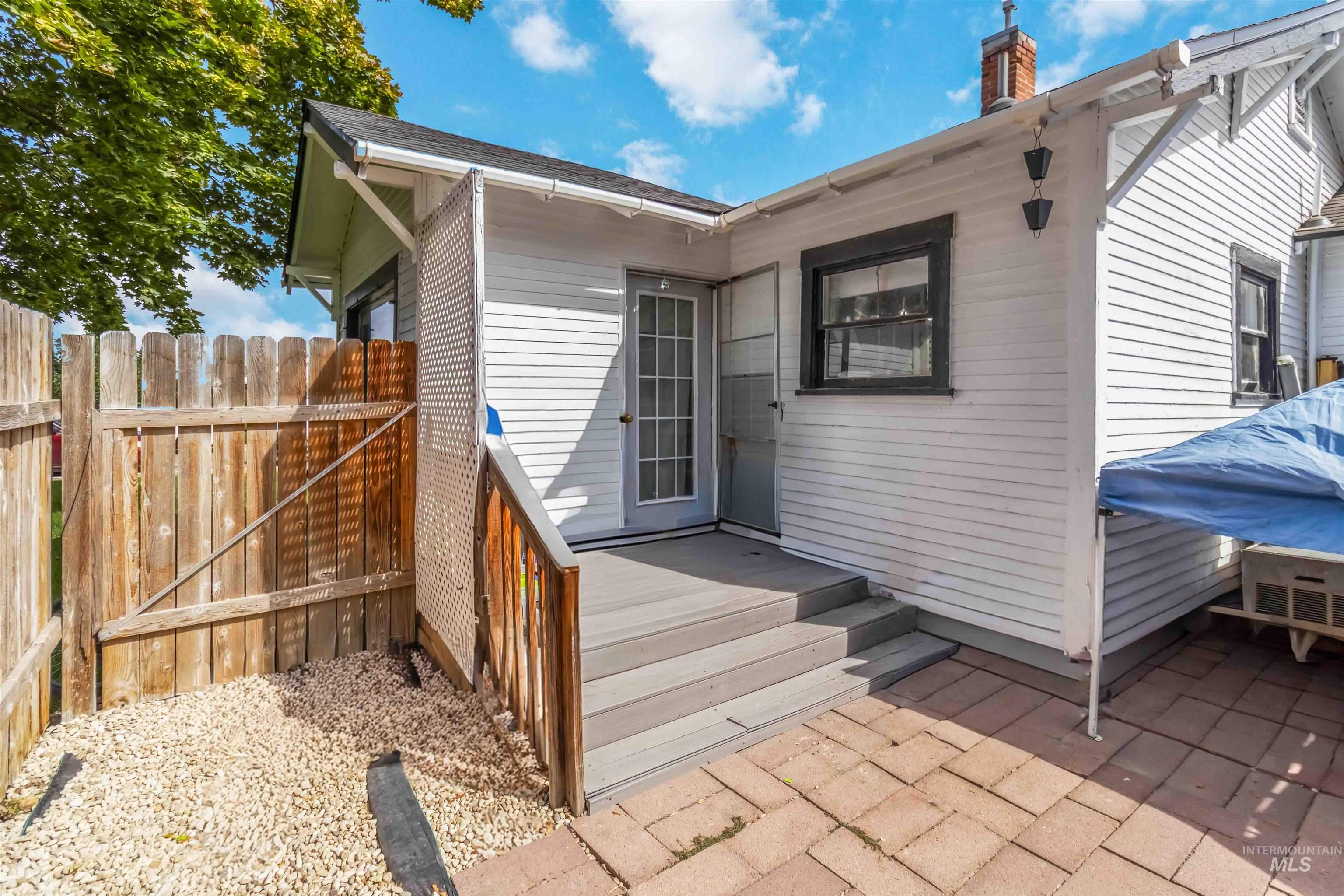 Property entrance with a wooden deck and a chimney