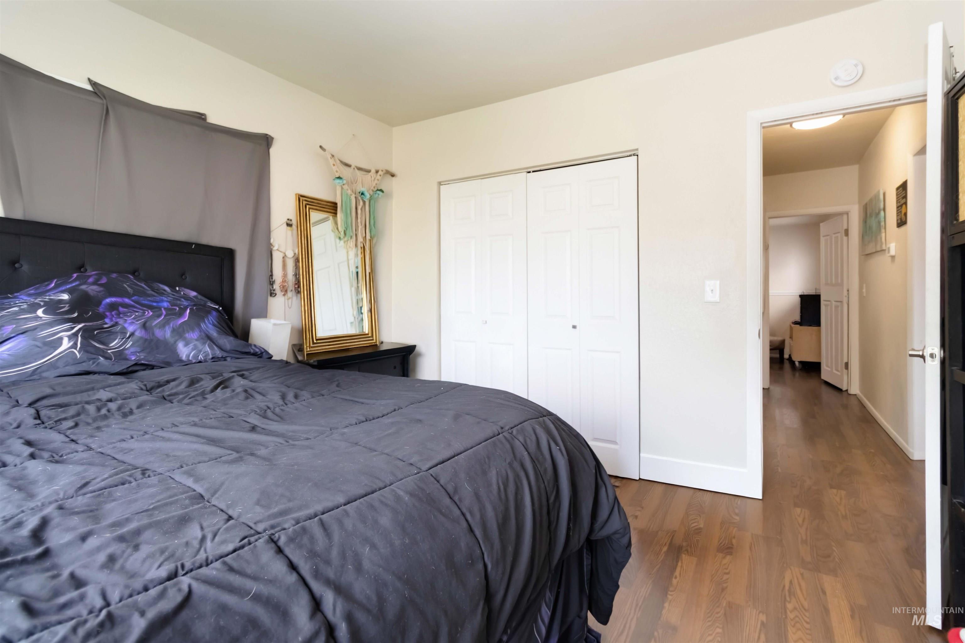 Bedroom featuring dark wood finished floors and a closet