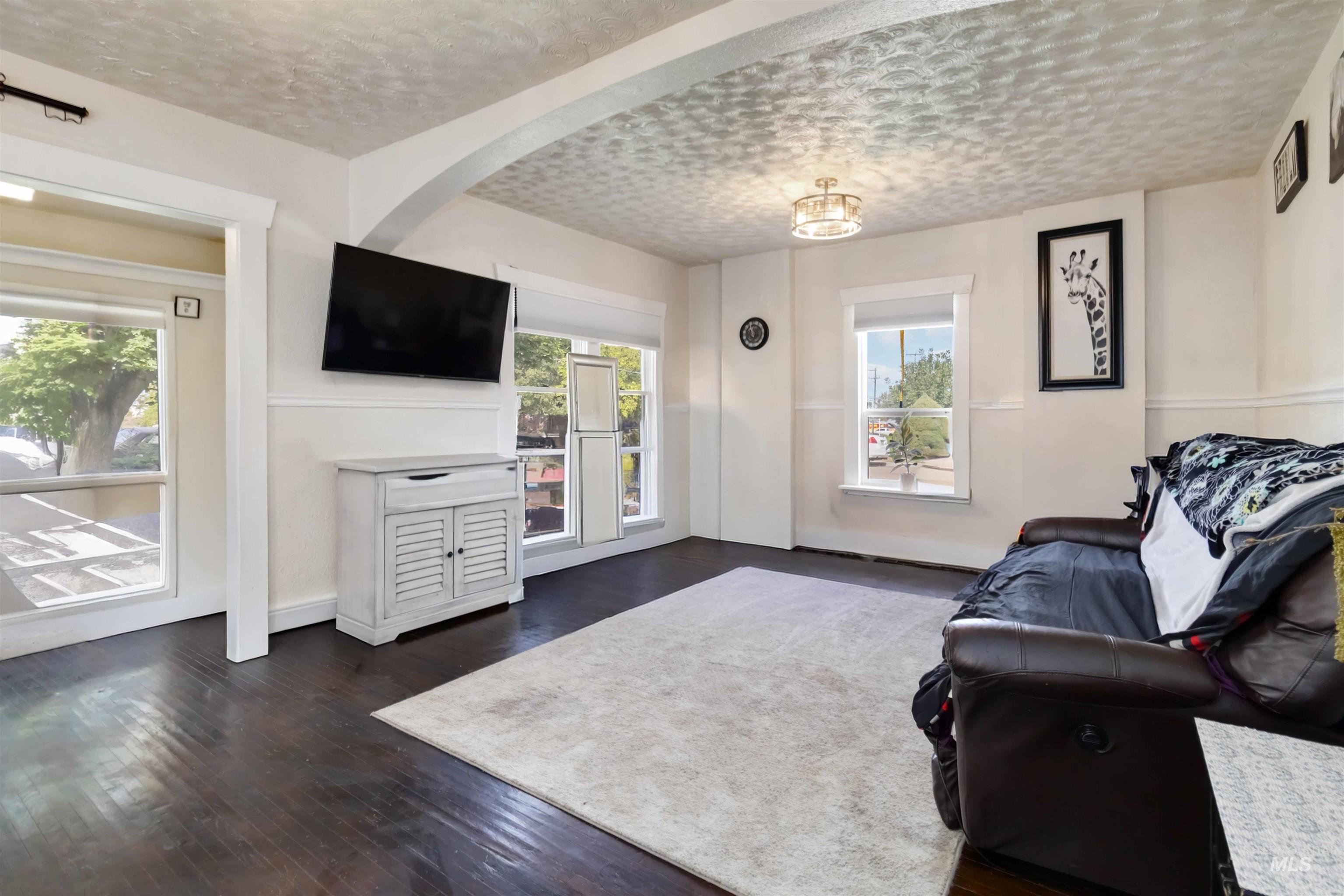 Living room featuring healthy amount of natural light, dark wood finished floors, and a textured ceiling
