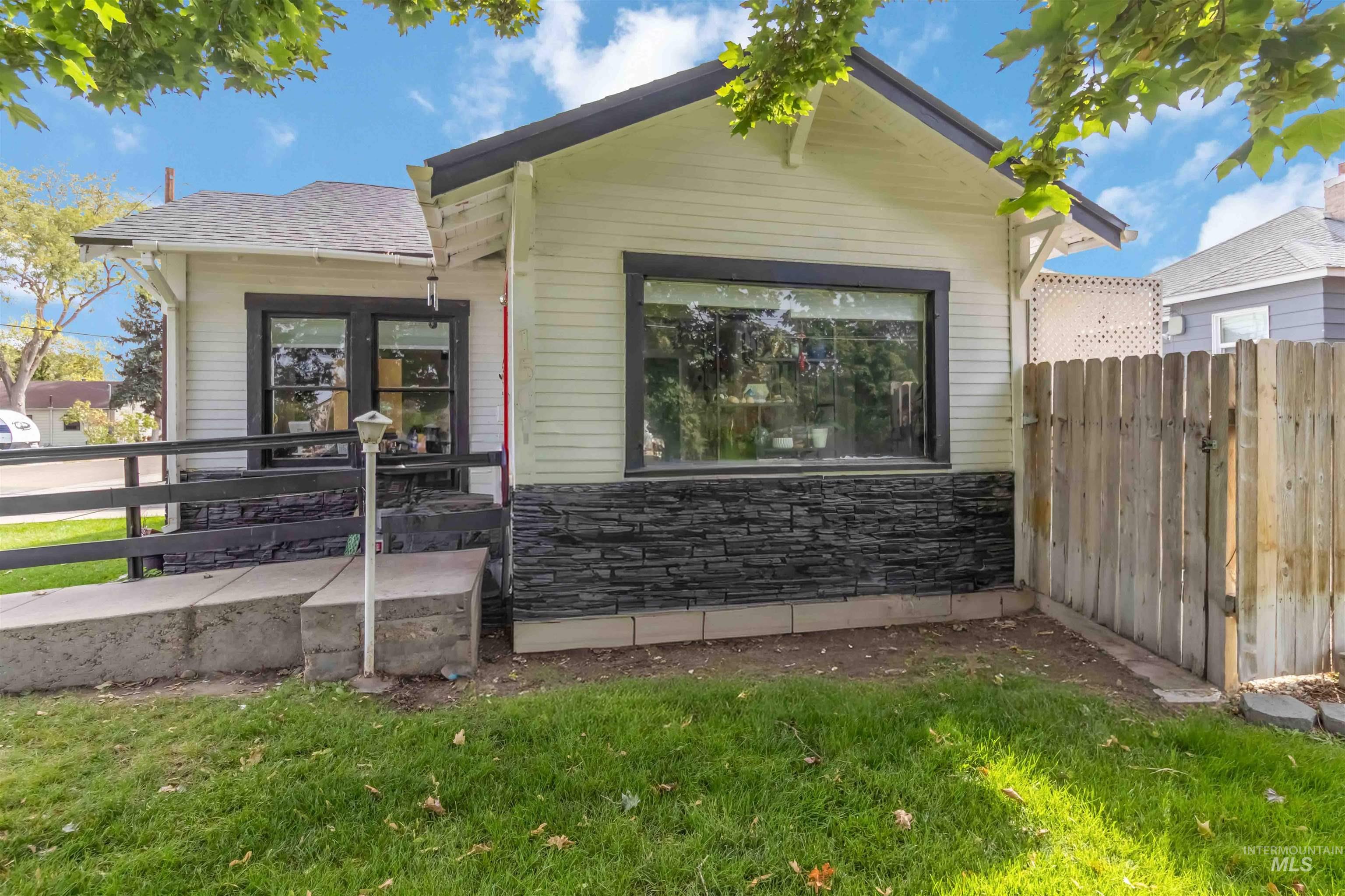 View of front facade with stone siding and a shingled roof