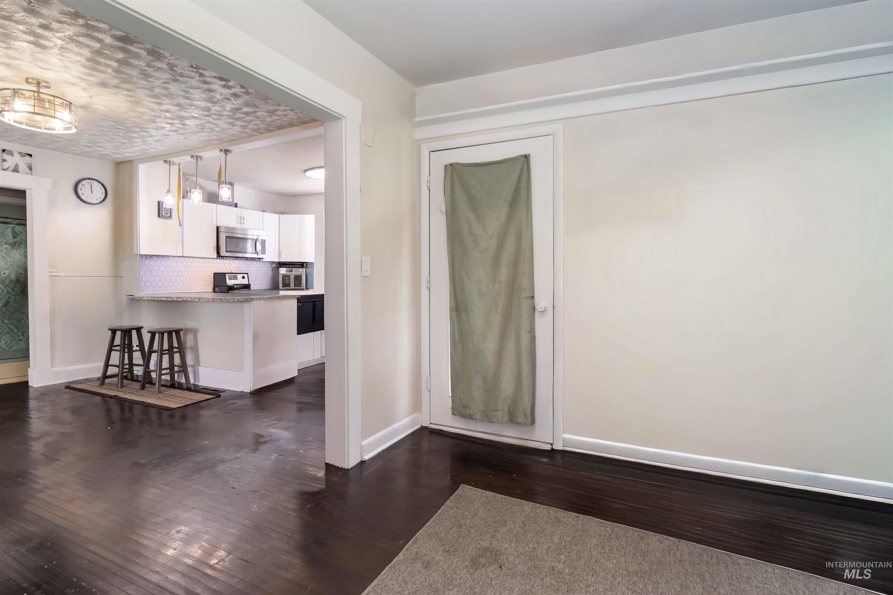 Foyer entrance with dark wood-style flooring and baseboards