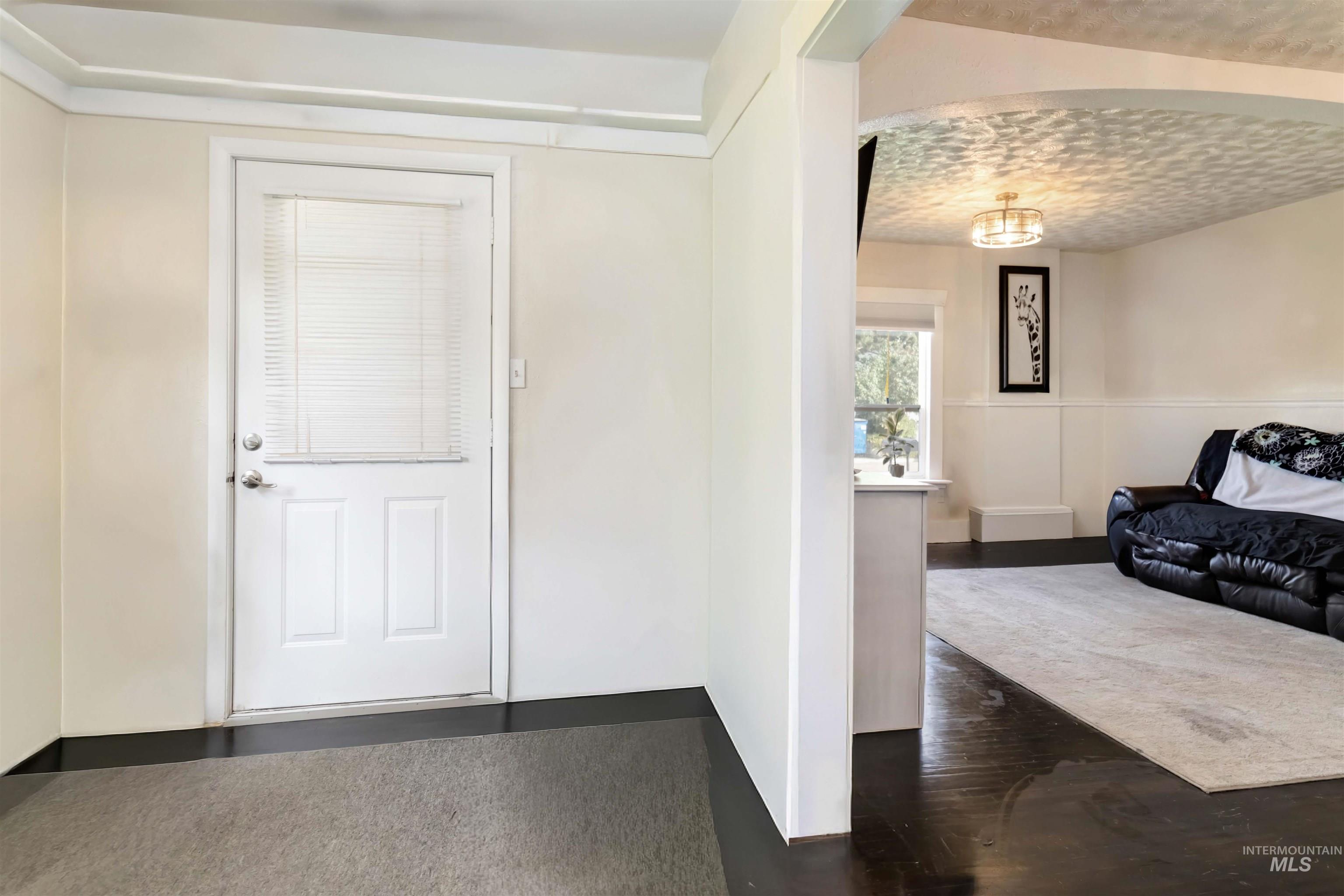 Foyer with arched walkways and dark wood finished floors