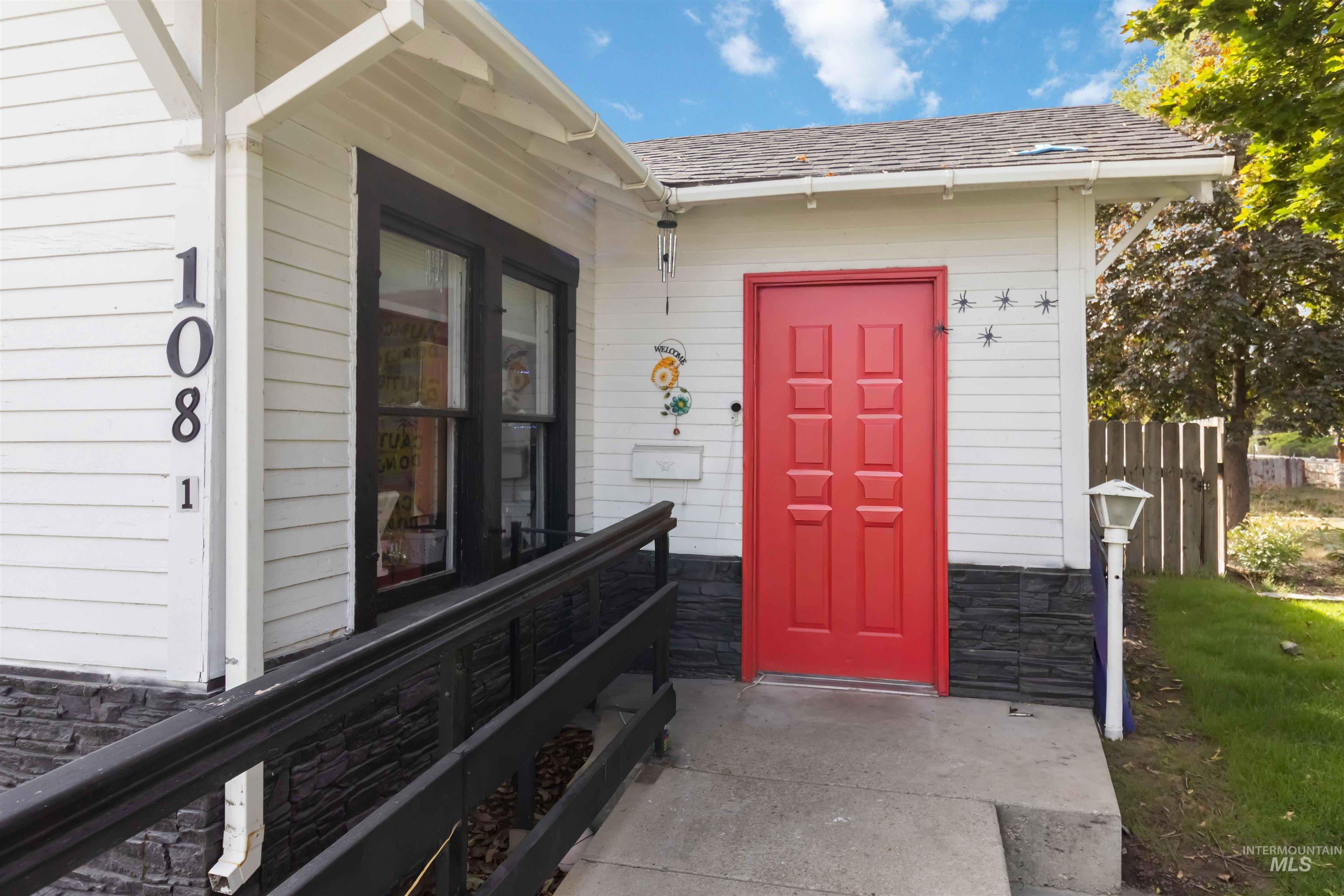 Doorway to property with roof with shingles and stone siding