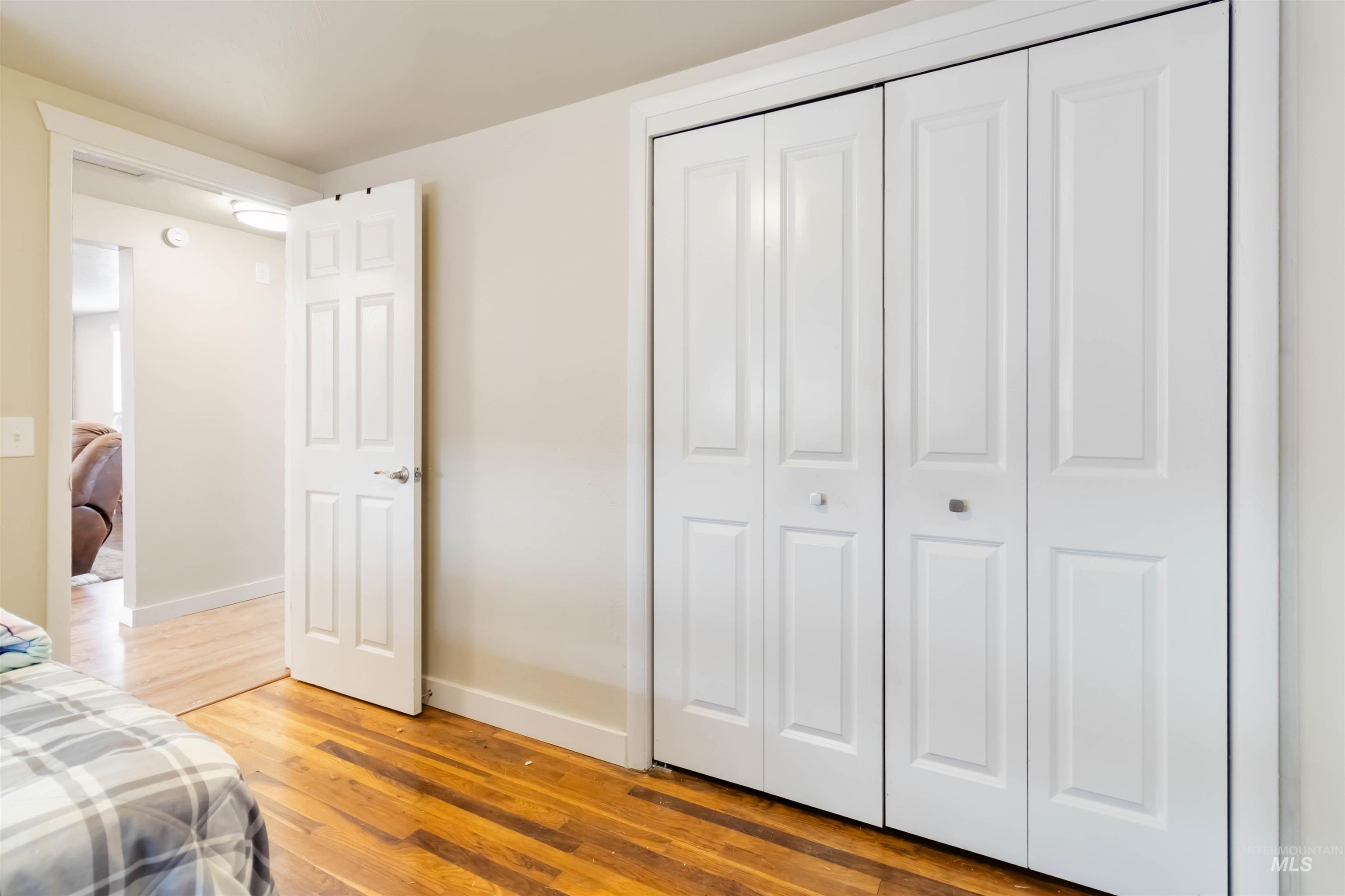 Bedroom with light wood finished floors and a closet
