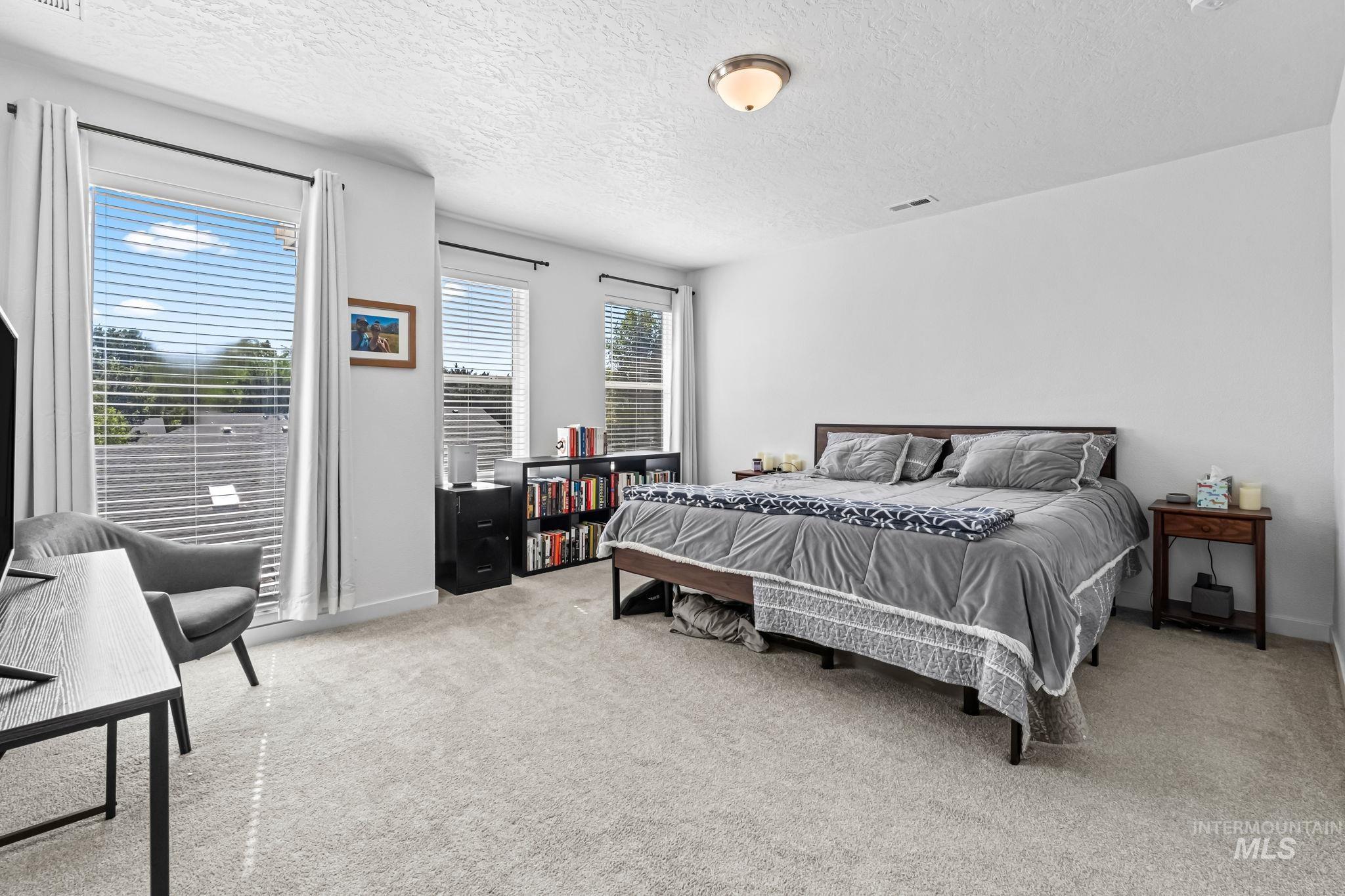 Bedroom with a textured ceiling and carpet