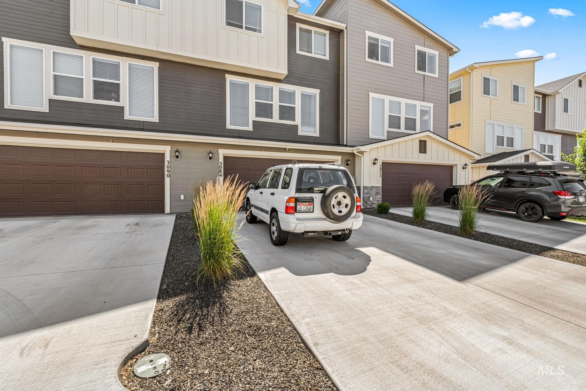 View of property featuring board and batten siding, driveway, and an attached garage