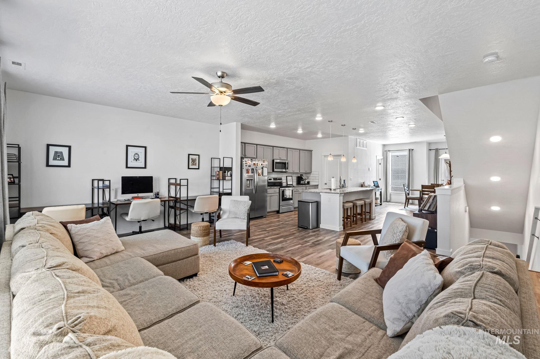 Living room featuring wood finished floors, a textured ceiling, ceiling fan, and recessed lighting
