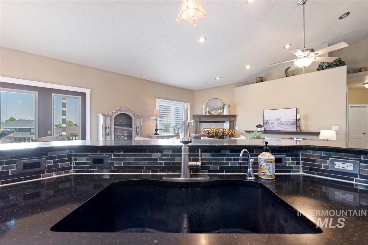 Kitchen with vaulted ceiling, french doors, recessed lighting, tasteful backsplash, and open floor plan