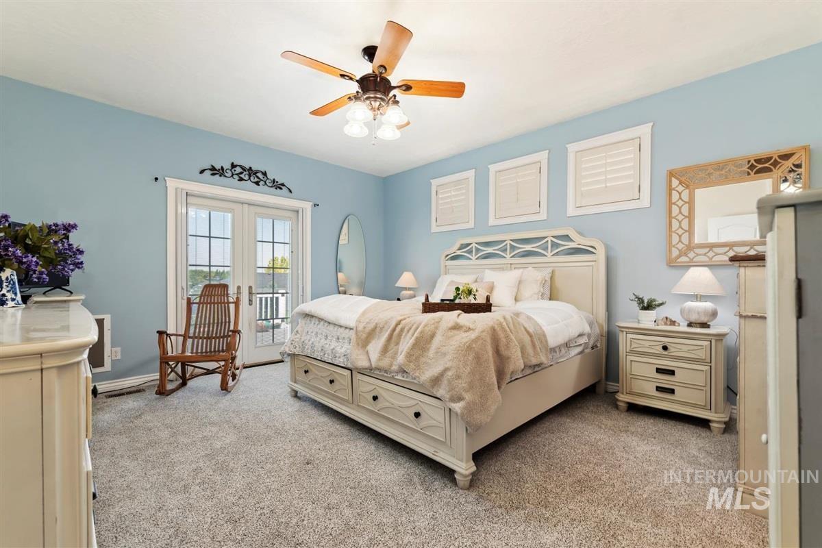Bedroom with access to exterior, light colored carpet, french doors, and ceiling fan