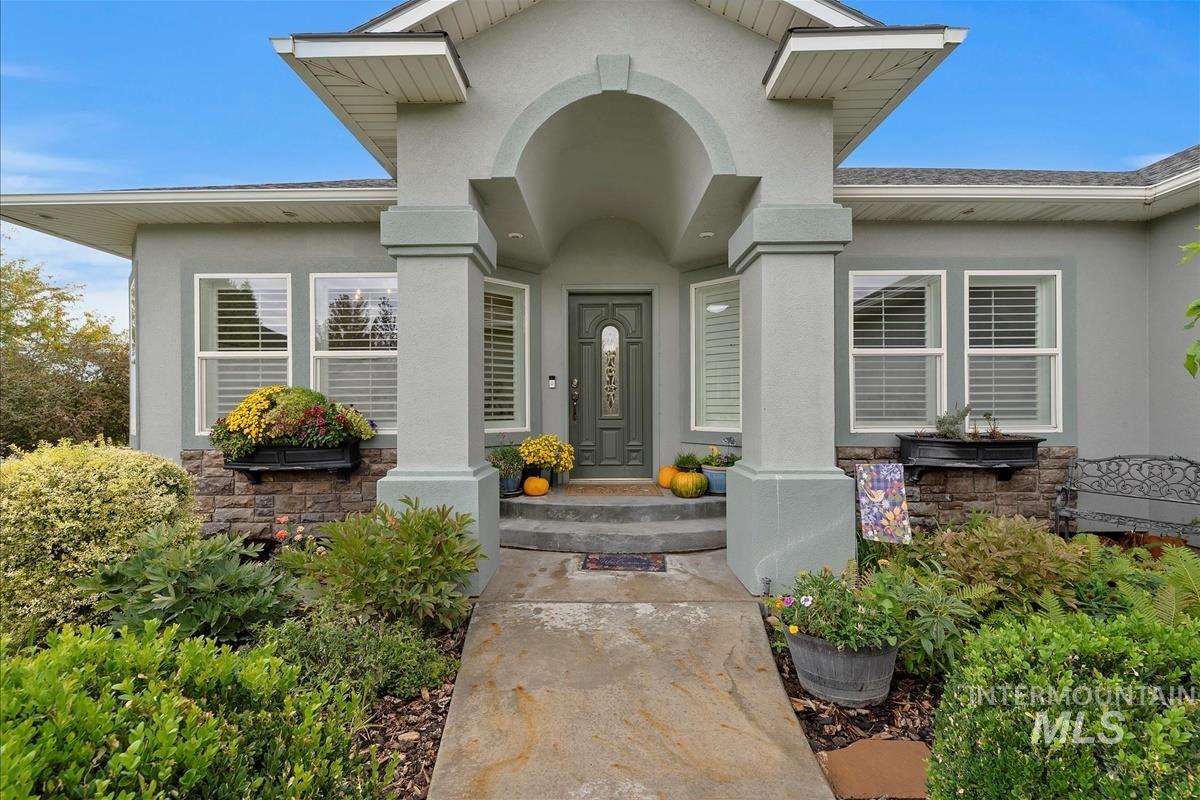 Doorway to property with stone siding and stucco siding