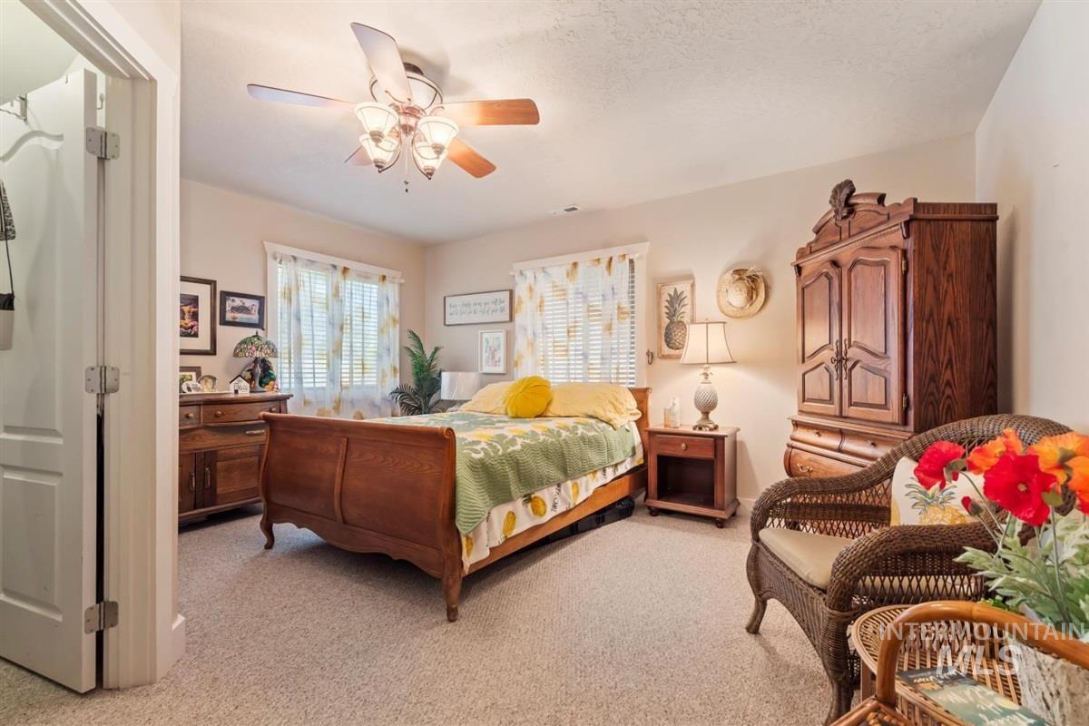 Bedroom with light colored carpet and ceiling fan